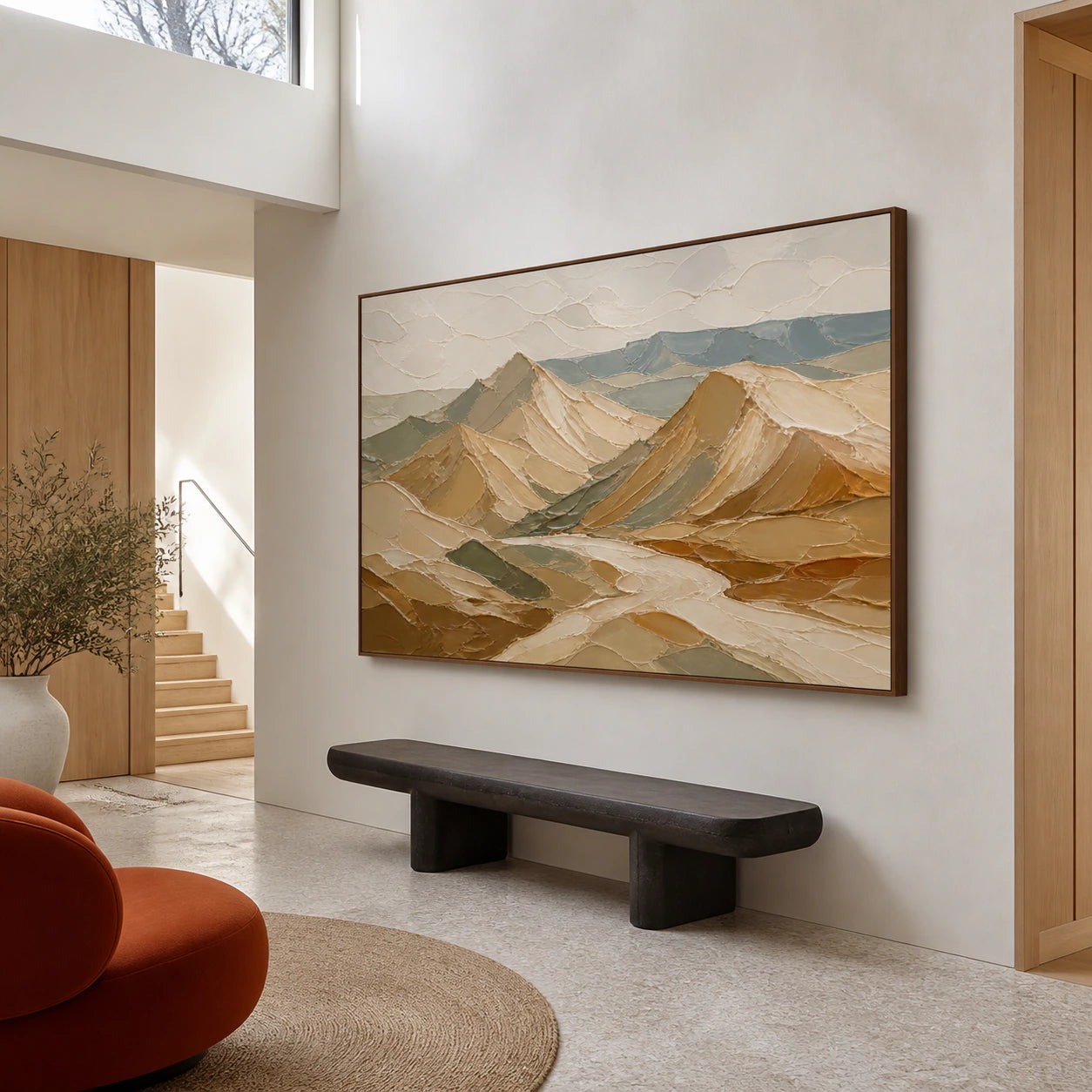Large ochre and blue-green mountain painting in a gallery-scale daylight foyer.