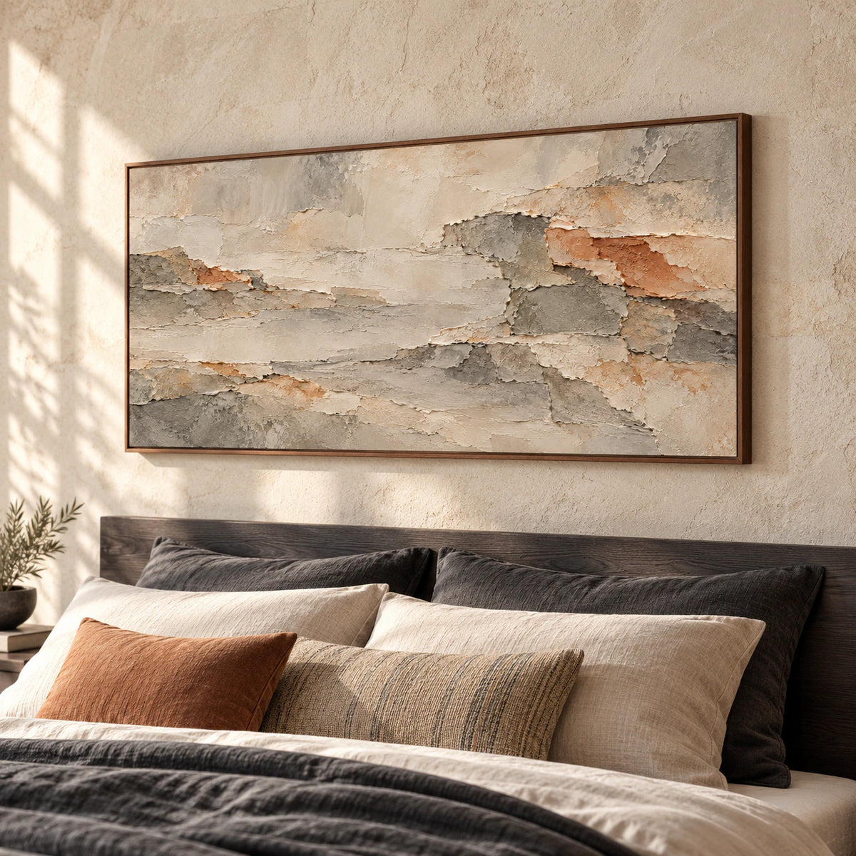 Ochre-Shards above a charcoal wood headboard in a quiet bedroom with pale walls and restrained bedding, viewed from a slightly elevated left-oblique angle.