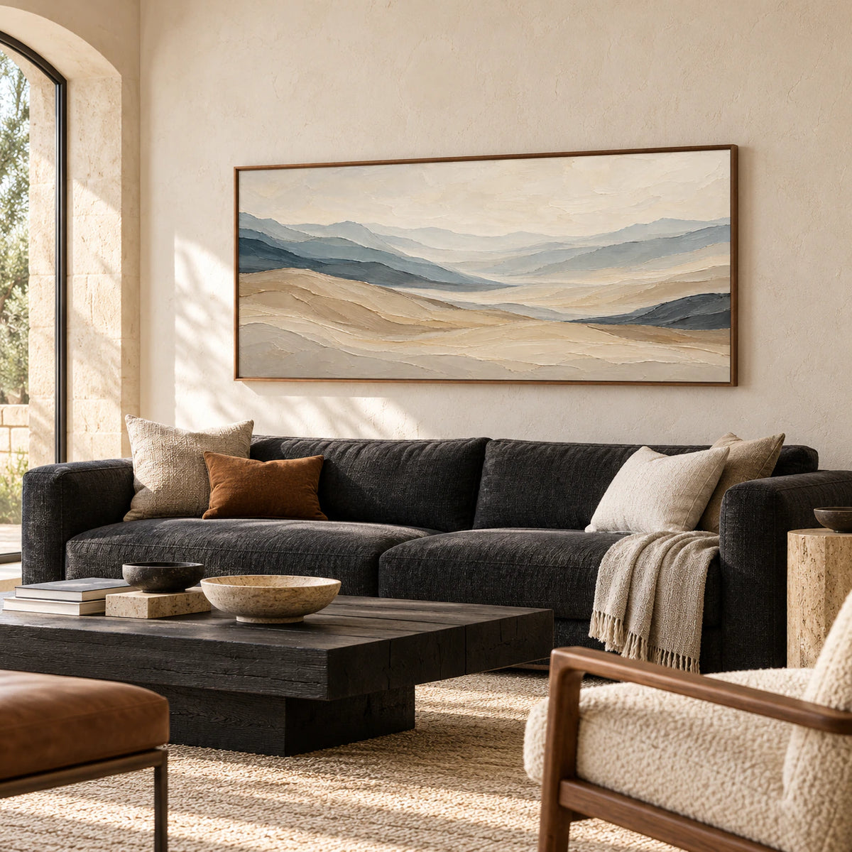 Ochre-Traverse above a charcoal sofa on a pale limestone wall, with a low blackened wood table, viewed from the left in daylight.