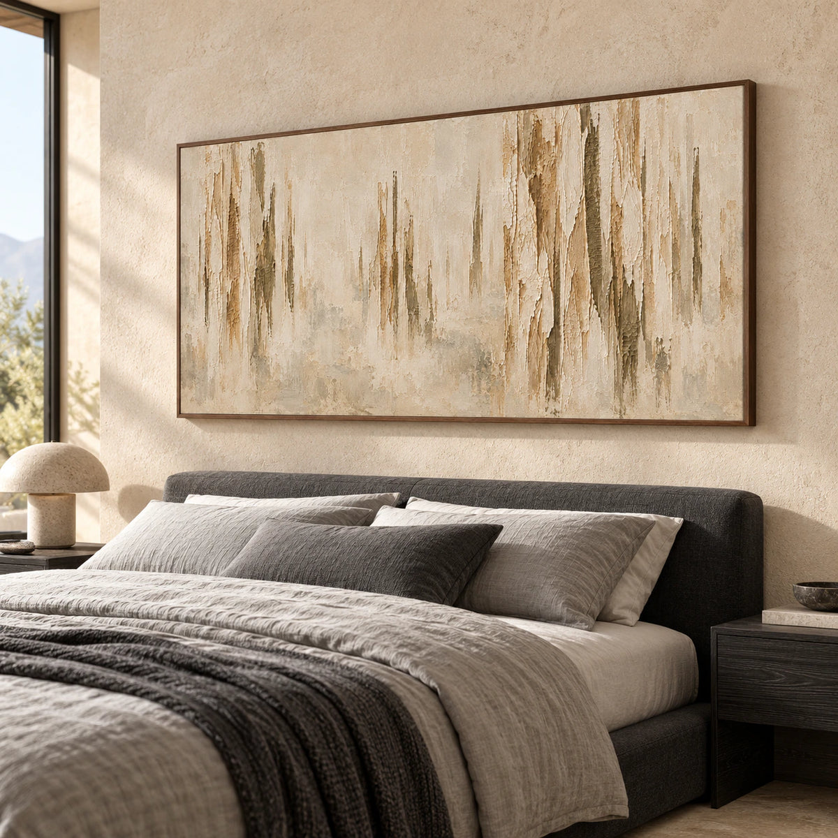 Large abstract artwork above a low bed in a quiet, sunlit bedroom with muted gray linen and simple timber details.