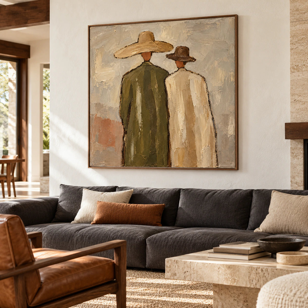 Paired-Silhouettes above a low charcoal sofa in a bright living room with pale walls and daylight.