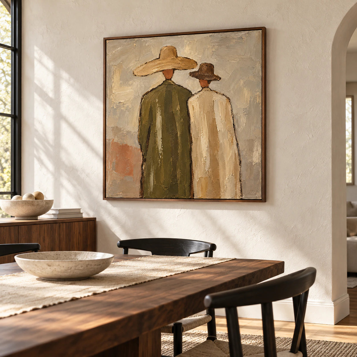 Paired-Silhouettes on a light plaster dining room wall above a long dark wood table and restrained furnishings.