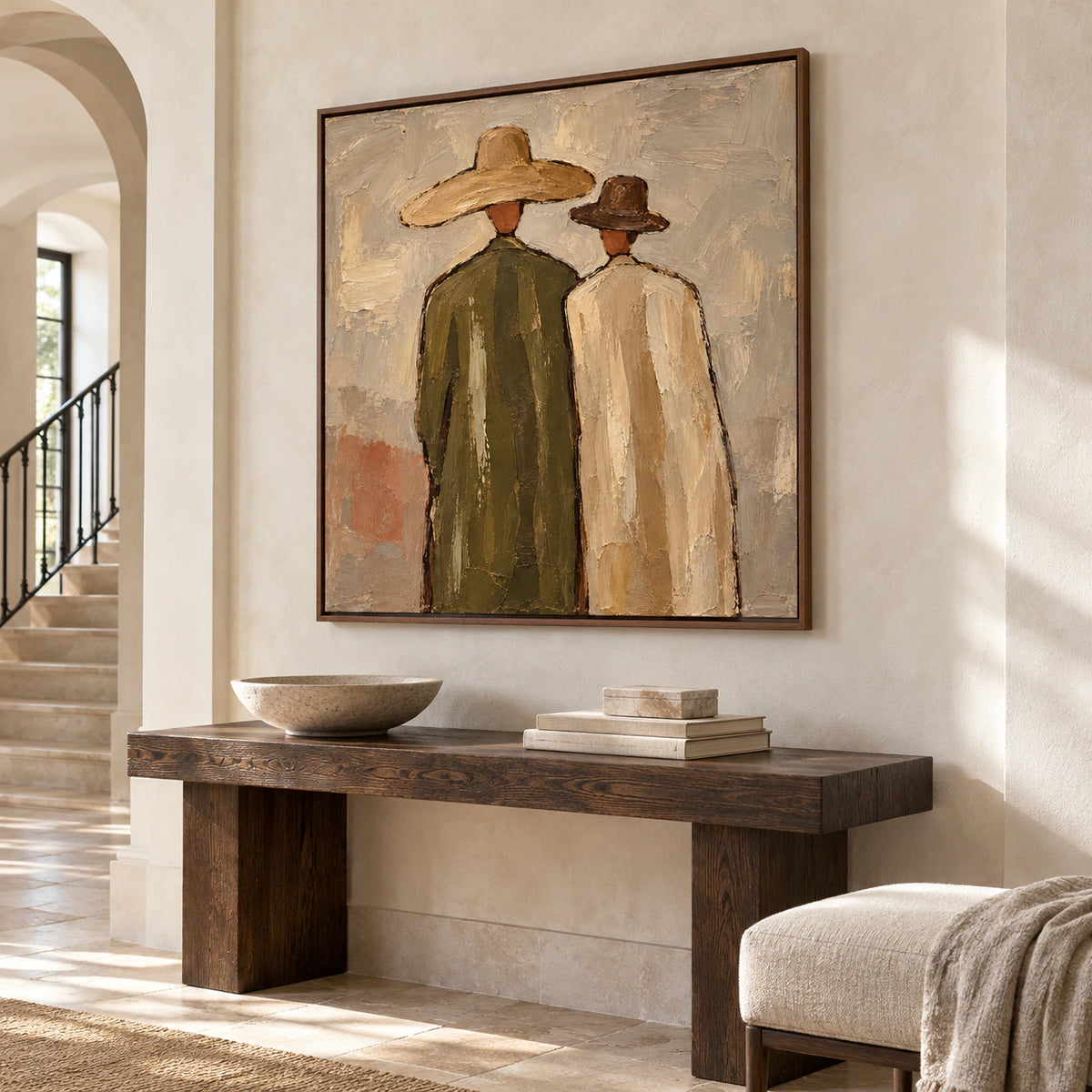 Large Paired-Silhouettes painting anchoring a bright foyer with pale stone walls and a dark console.