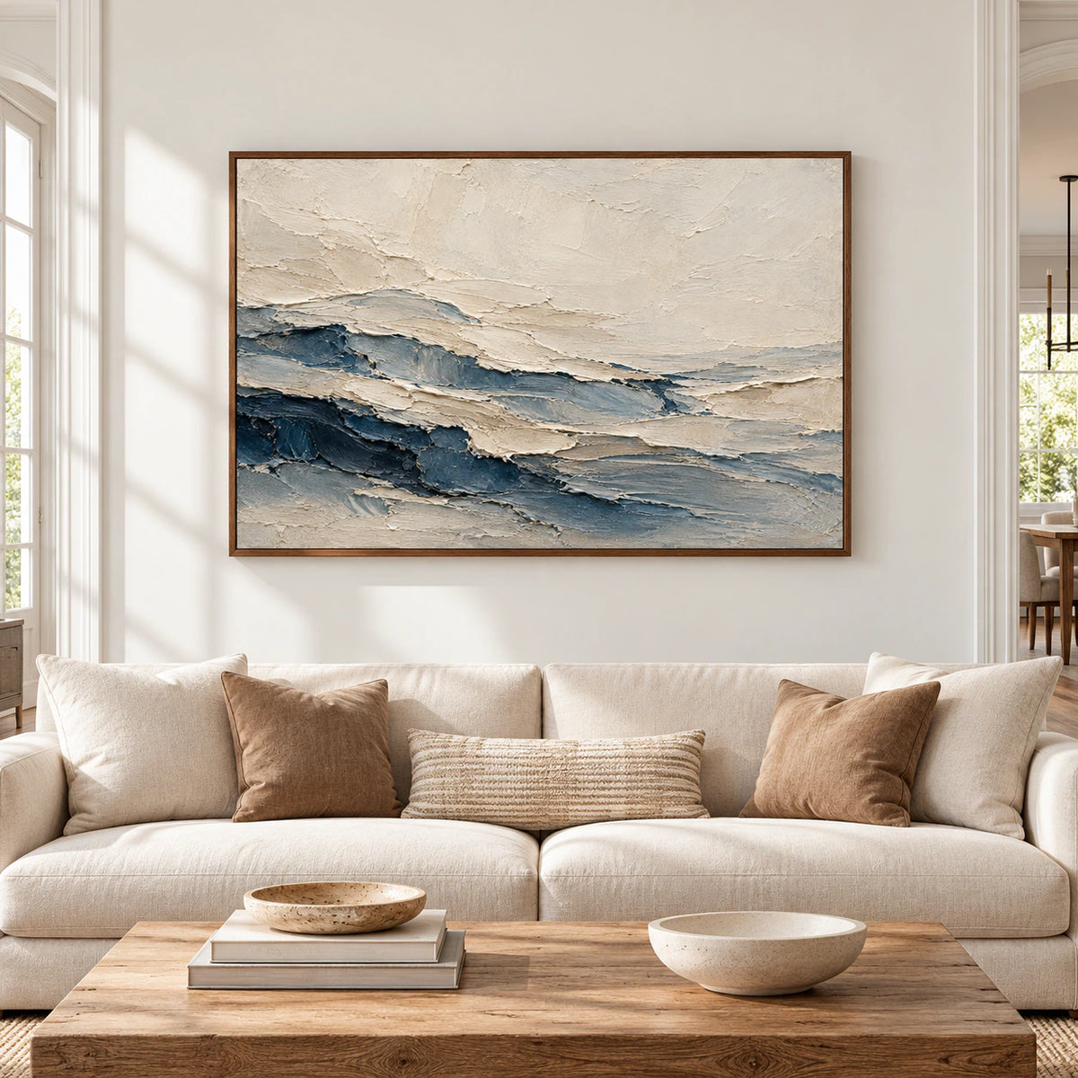 Large cream and slate blue abstract painting viewed straight on in a bright, open living room with restrained neutral furnishings.