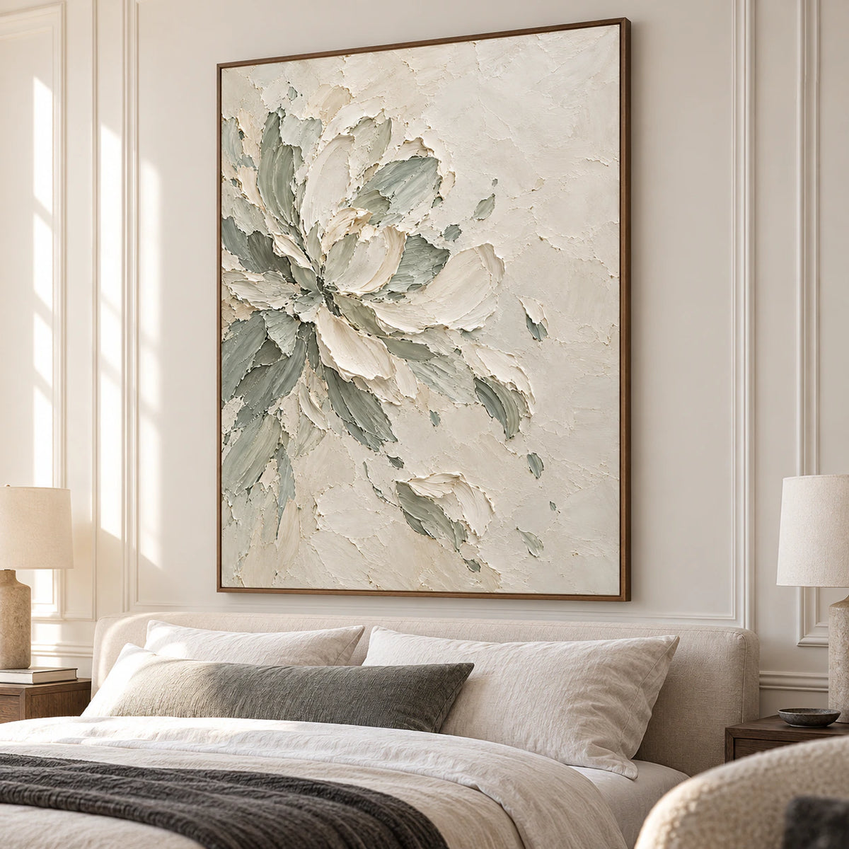 Ivory and sage floral artwork above a low bed in a quiet bedroom with pale linen, warm wood and gentle daylight.