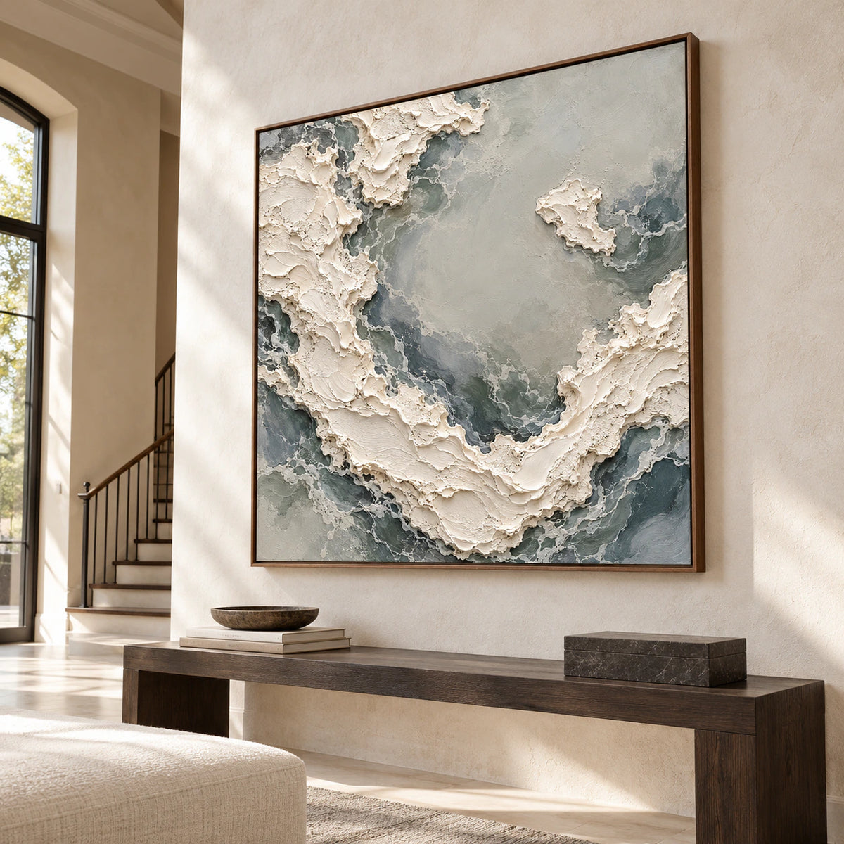 Pale-Torrent on a tall ivory stone foyer wall above a minimal dark wood console, viewed from a low angle on the left in natural daylight.