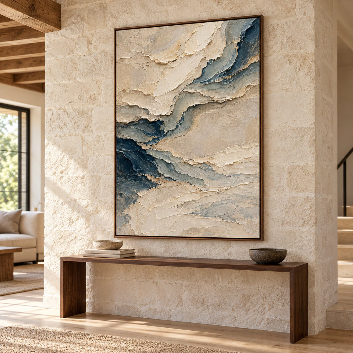 Pale-Undertow above a narrow dark wood console on a tall pale stone foyer wall, viewed slightly from below and to the right in natural daylight.