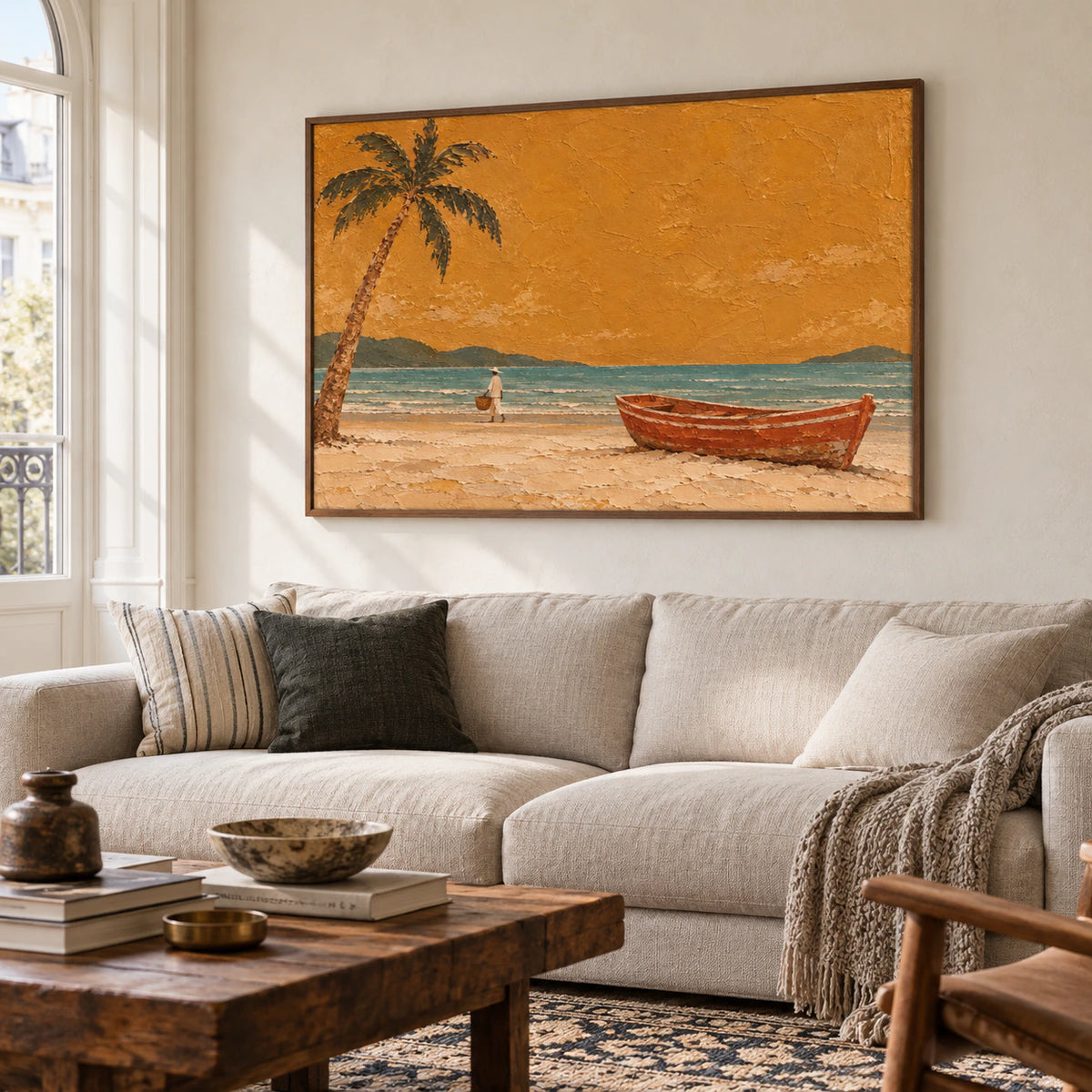 Coastal painting above a neutral sofa on a pale plaster wall in a bright, open living room, viewed from a gentle left angle at seated eye level.