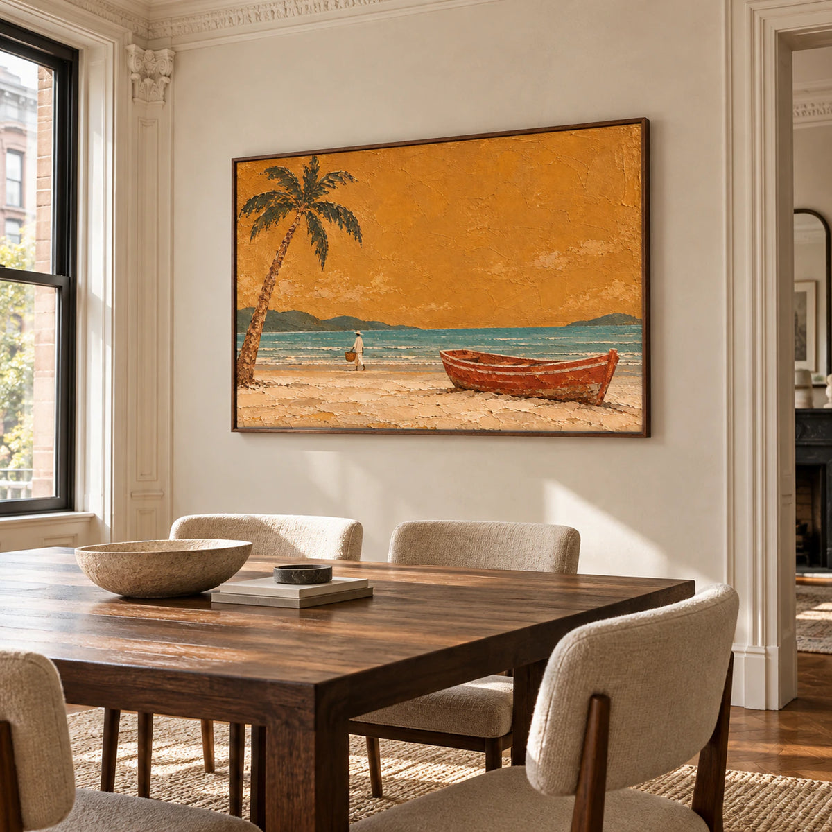 Coastal painting on a light limestone wall beside a dark wood dining table and muted upholstered chairs, viewed from the right in natural daylight.