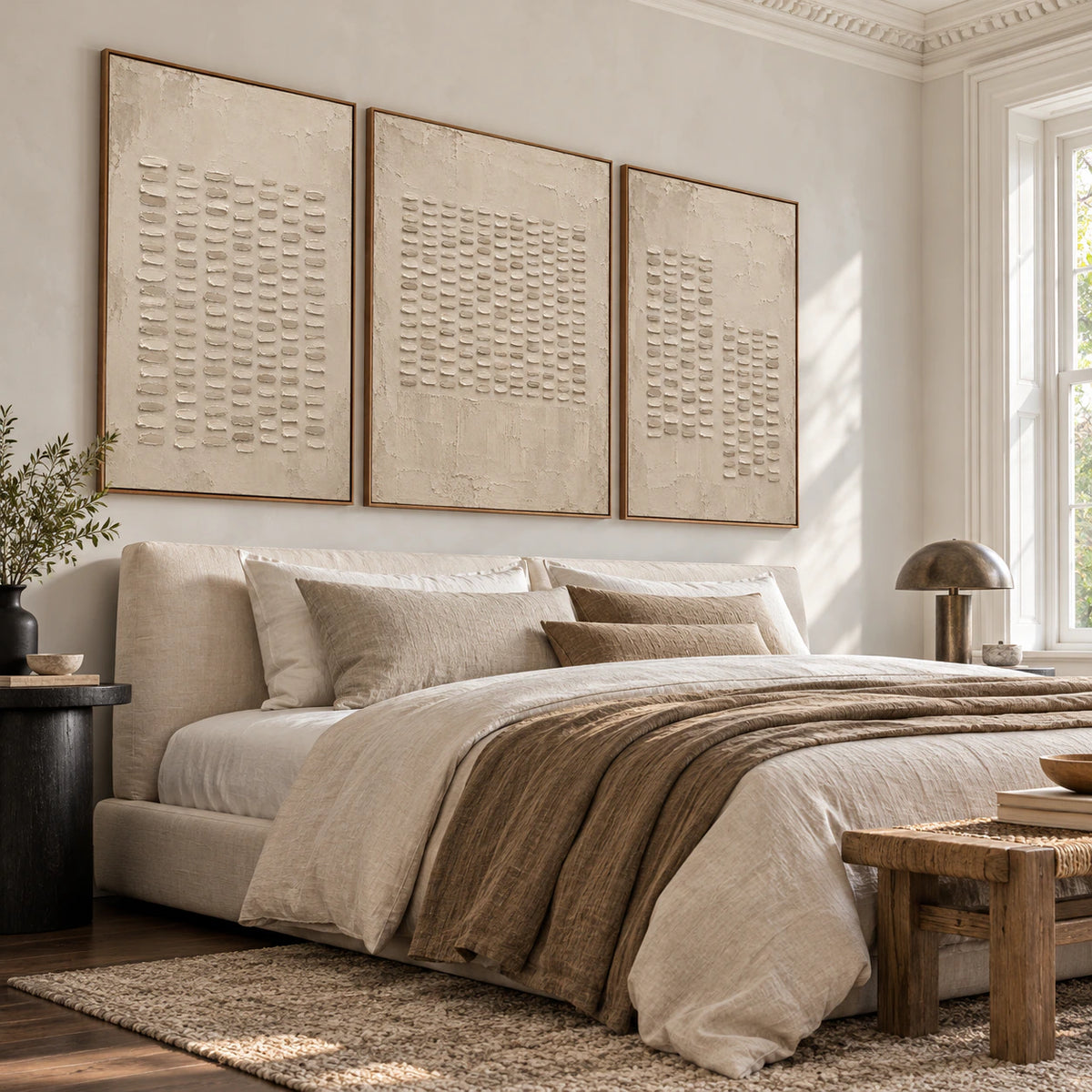 Quiet bedroom featuring the Parchment-Ciphers set of three above a low upholstered bed.