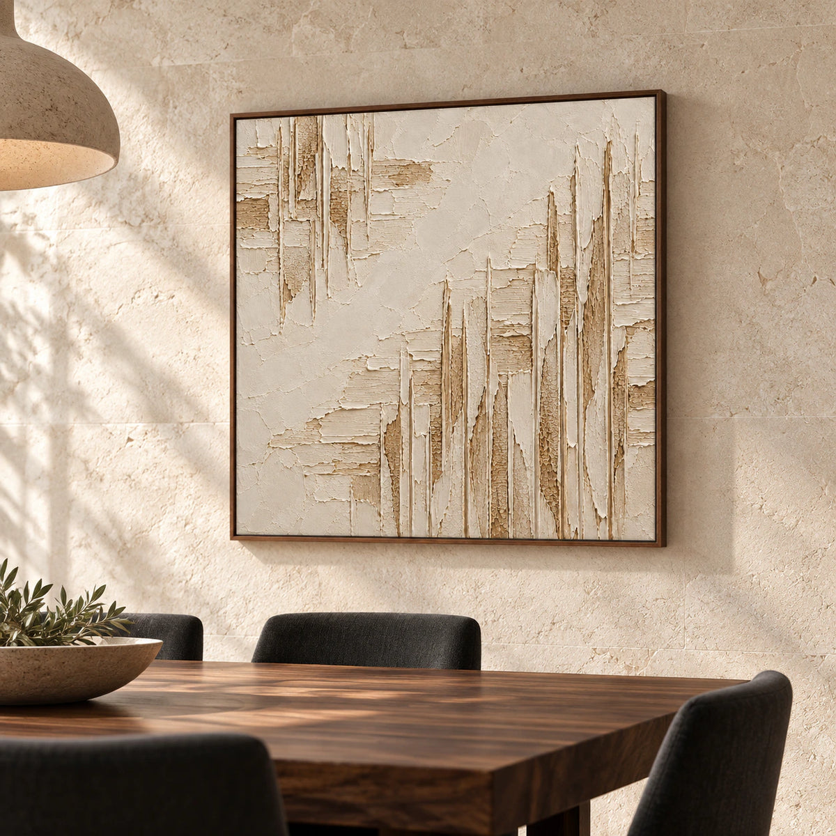 Square ivory relief artwork anchoring a refined dining room with a dark timber table and light stone walls.