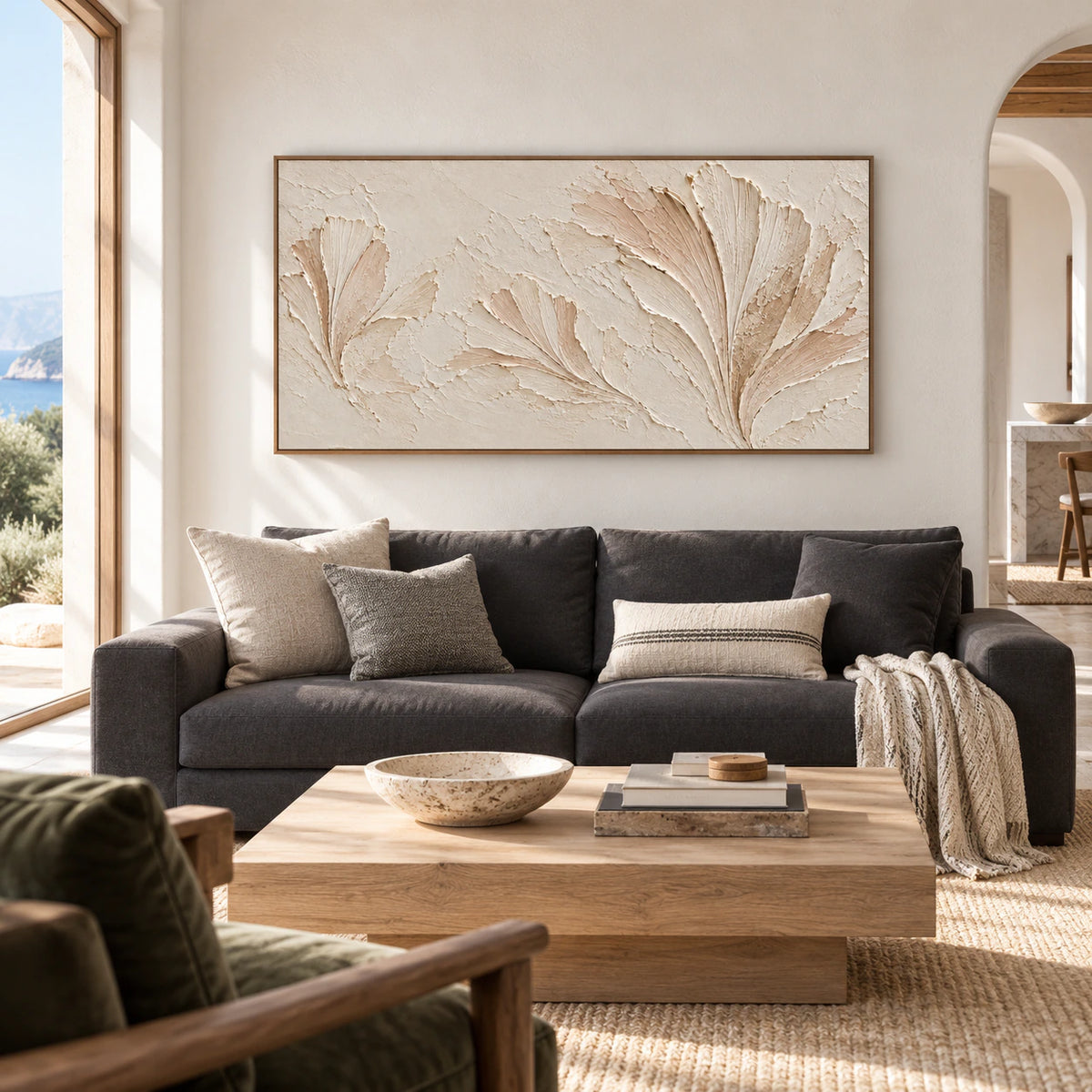 Parchment Fronds above a charcoal sofa in a bright living room with pale stone walls and broad windows.