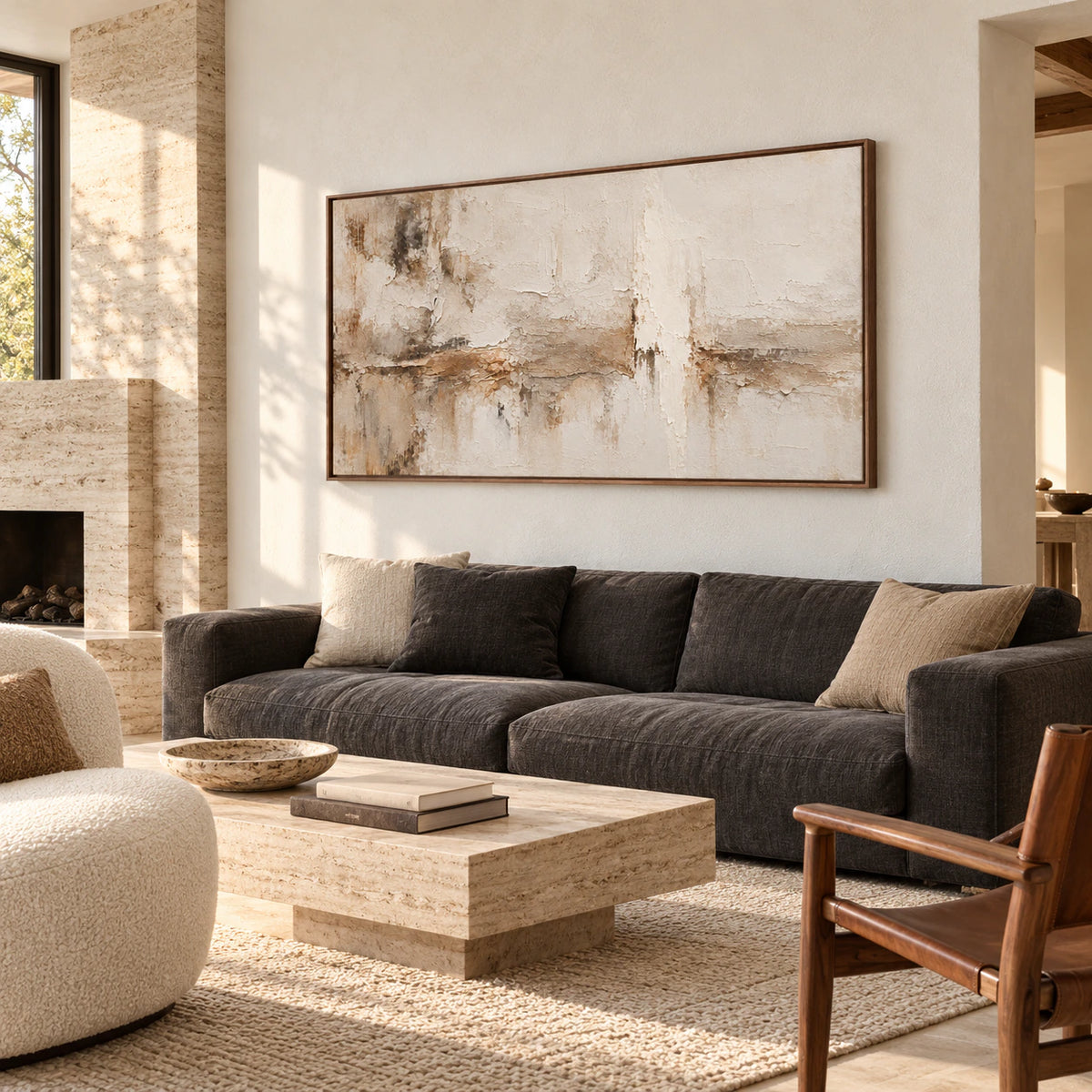 Large horizontal Parchment-Weather painting above a charcoal sofa in a bright living room with pale walls and natural daylight.