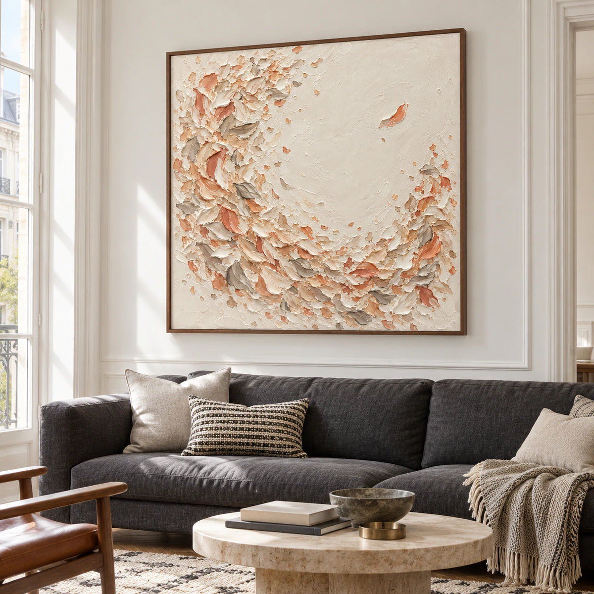 Large square artwork centered above a charcoal linen sofa in a bright living room with generous windows and restrained furniture.