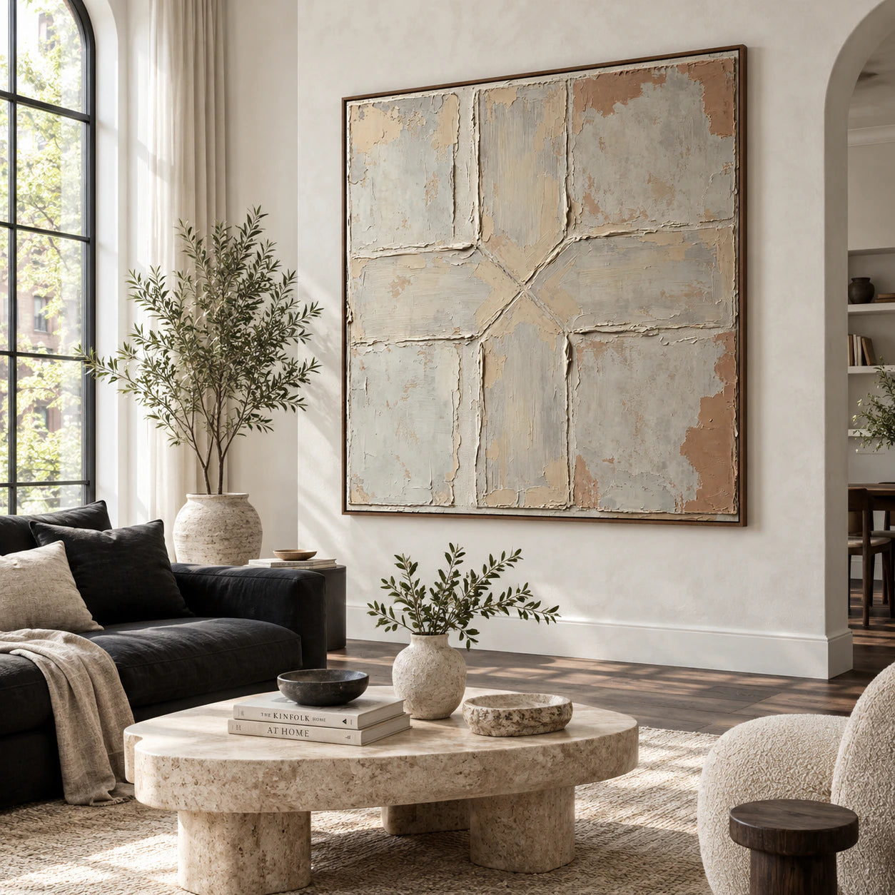 Square textured abstract artwork above seating in a bright living room.