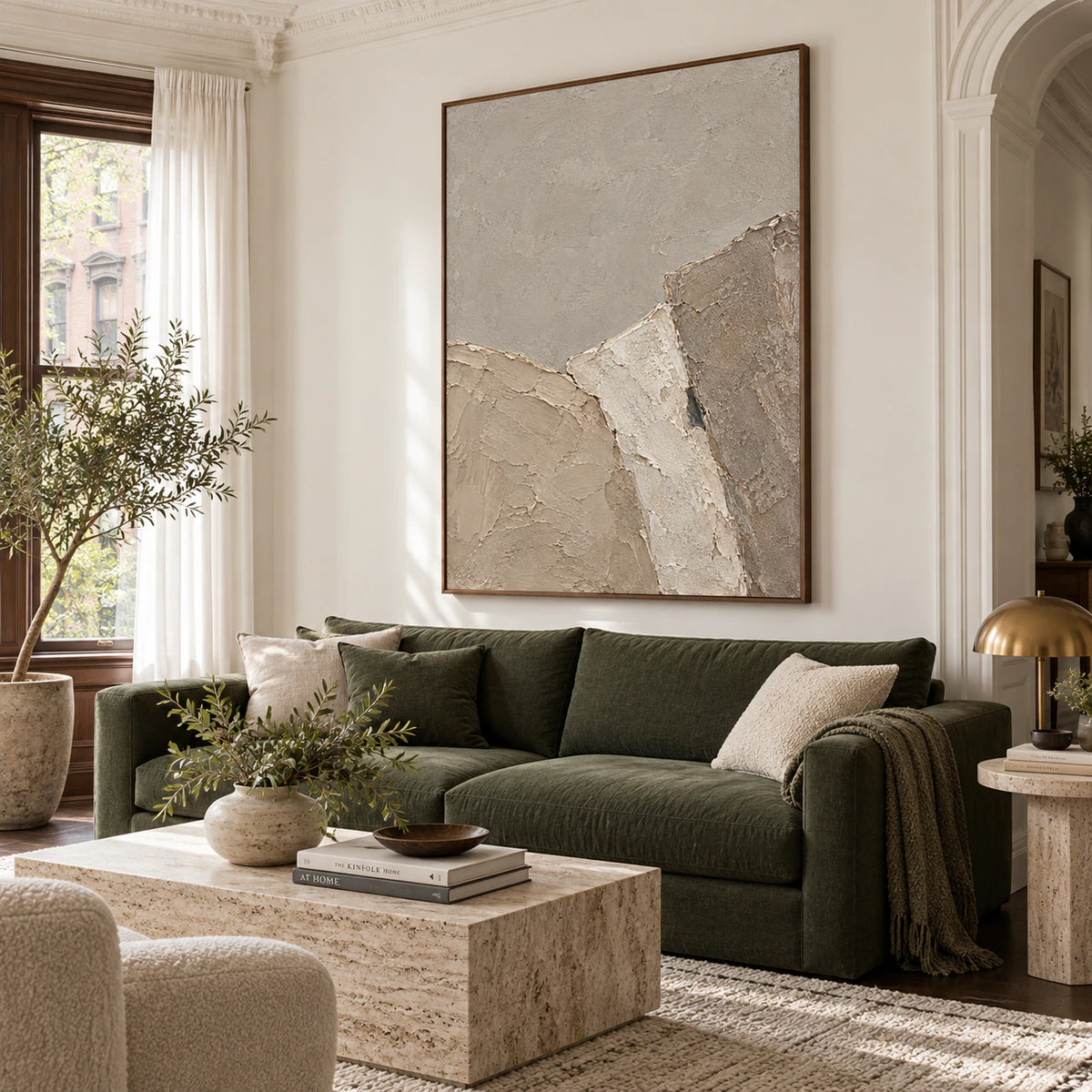 Vertical neutral textured abstract painting above a sofa in a bright living room.