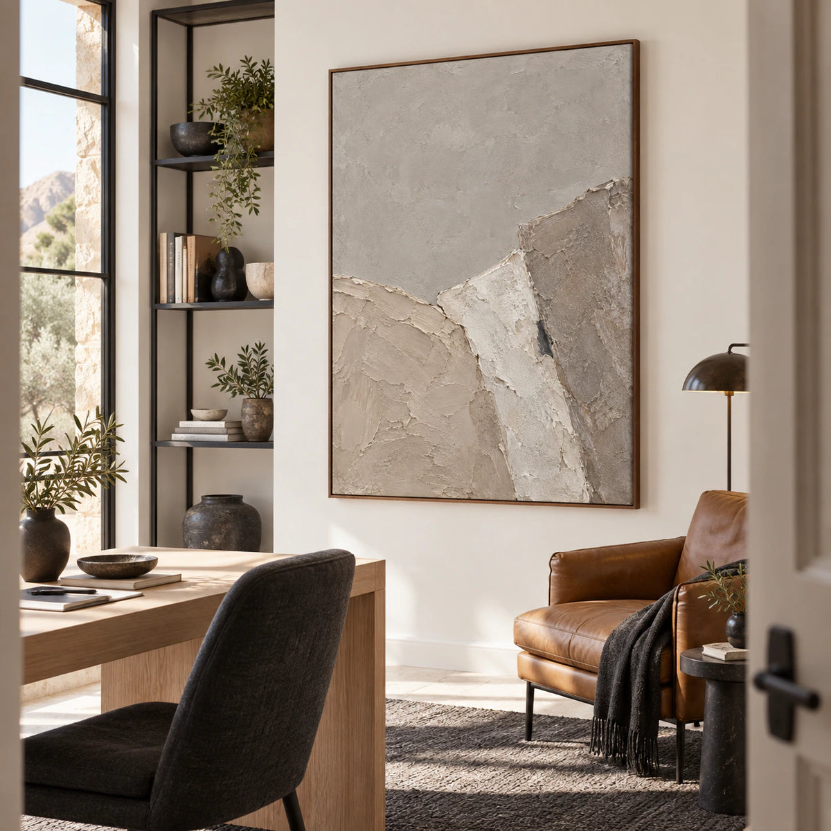 Neutral textured abstract wall art in an airy home office reading space.