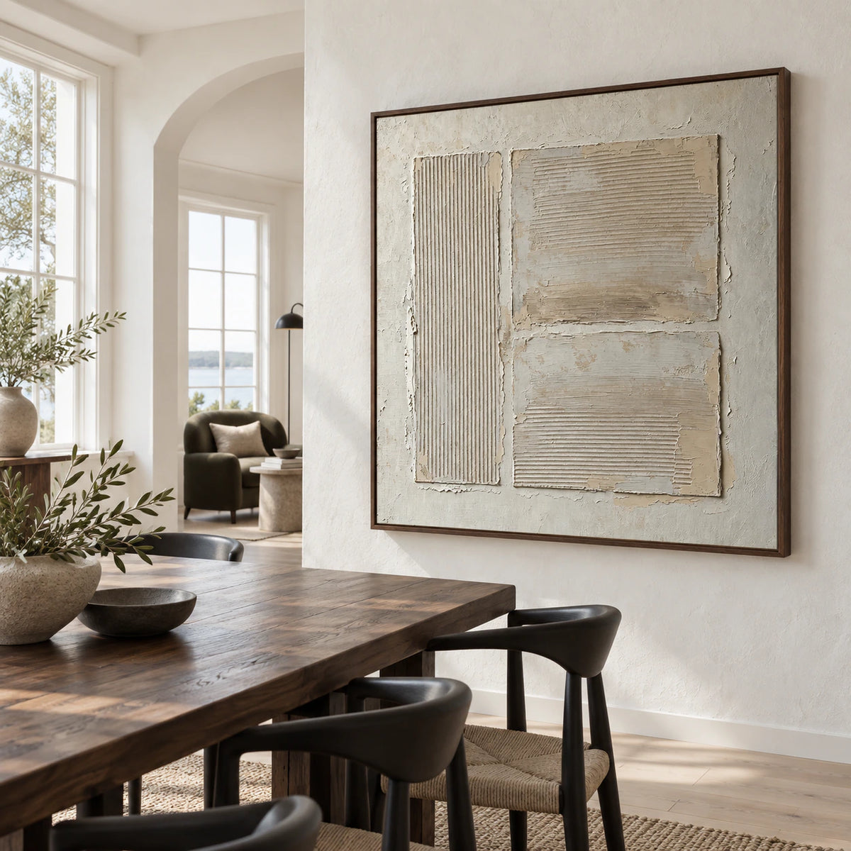 Square ivory relief artwork in a refined daylight dining room.