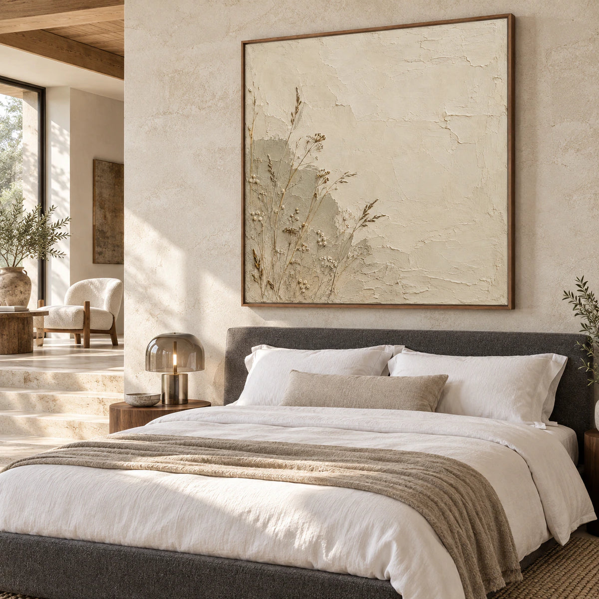 Square dried-stem plaster artwork above a low bed in a quiet bedroom.