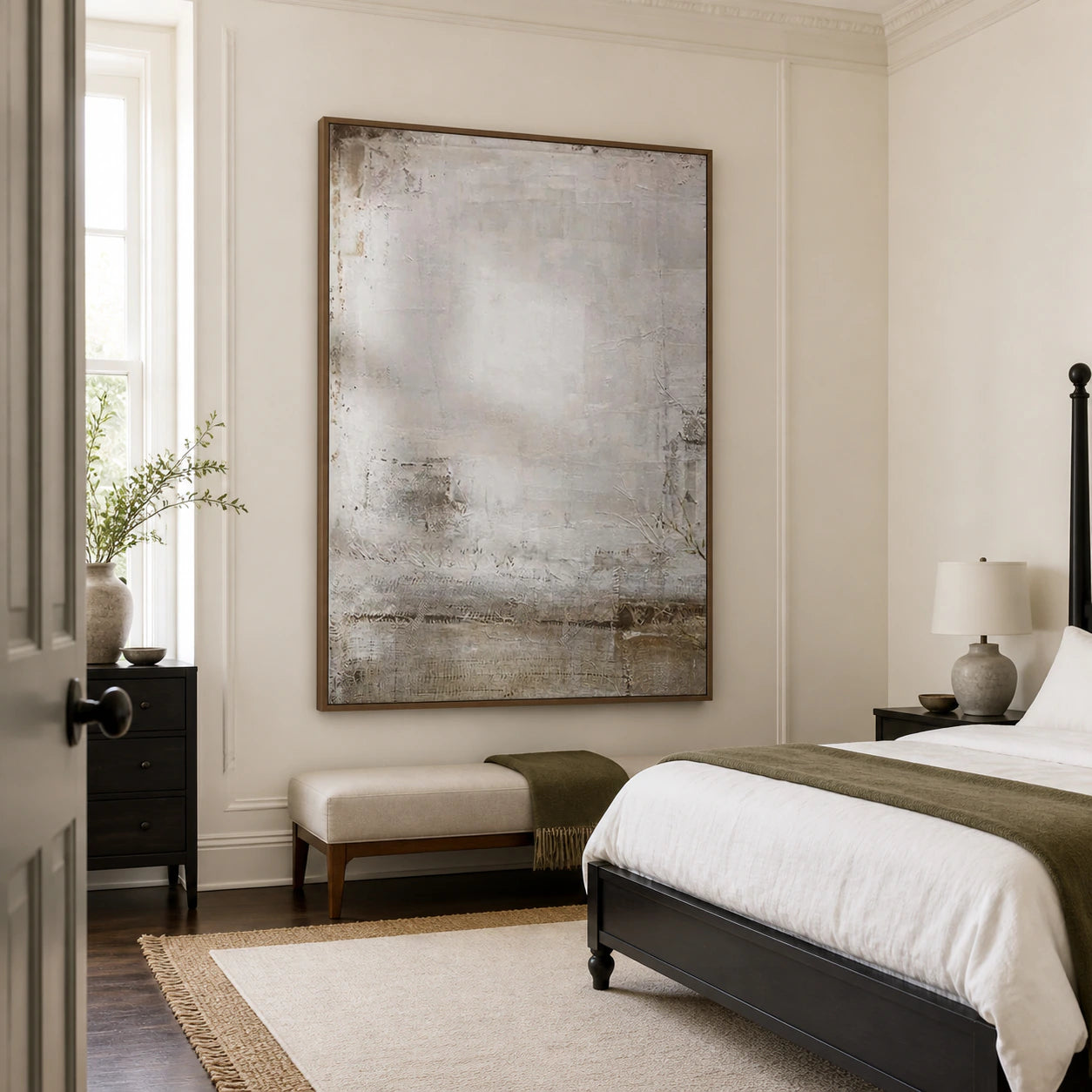 Pale textured abstract painting above a quiet bedroom seating area.