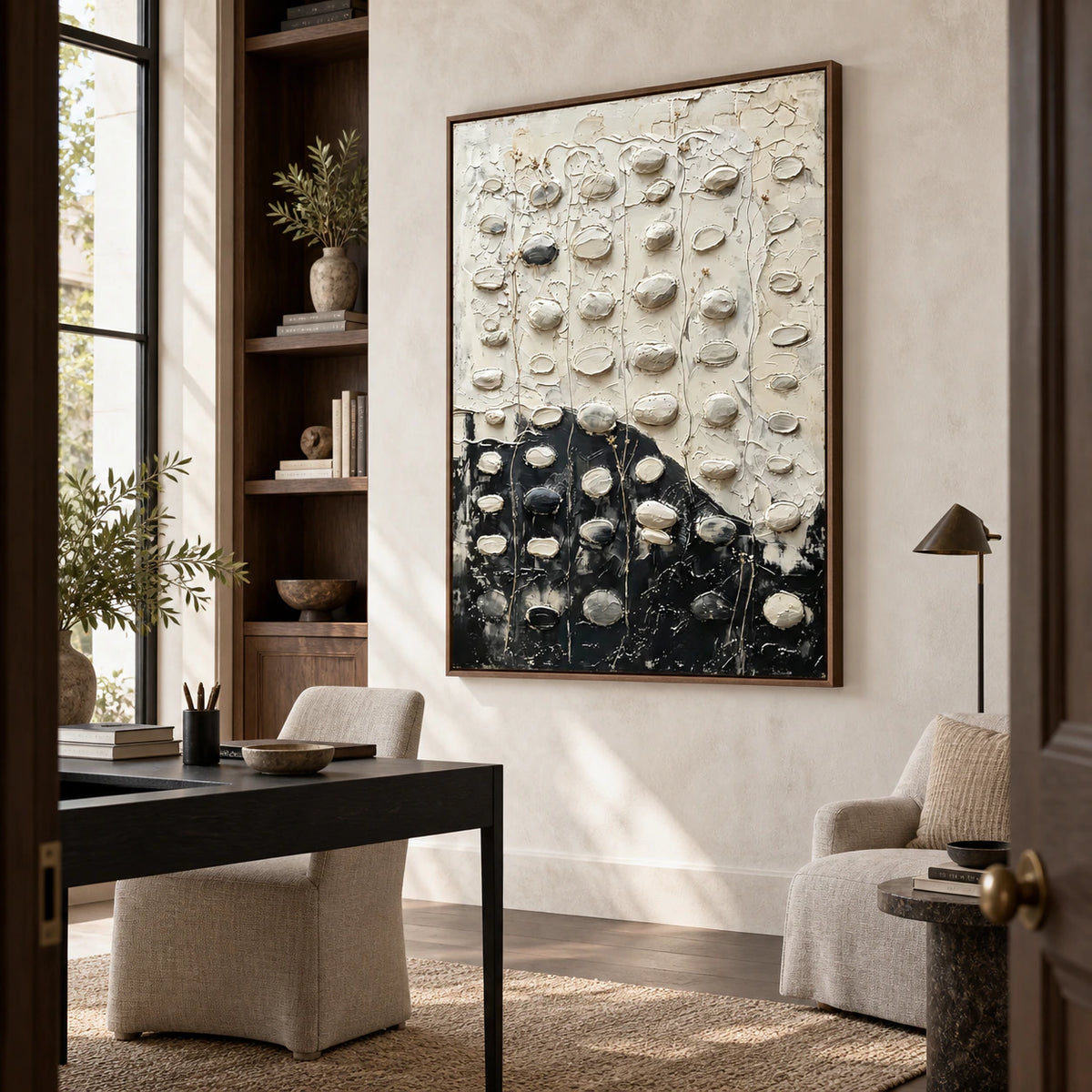 Raised black-and-white abstract artwork in a bright home office reading space.