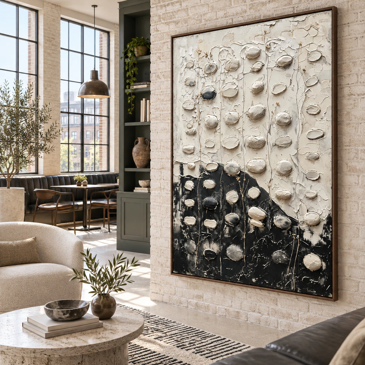 Large textured black-and-white painting in a luminous contemporary loft interior.