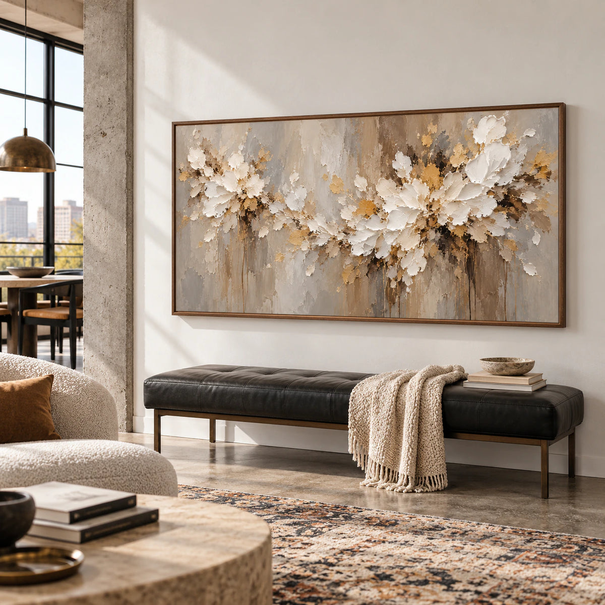 Right oblique view of a large horizontal ivory floral painting above a black leather bench in a bright, spacious loft with high ceilings, exposed concrete and neutral furnishings.
