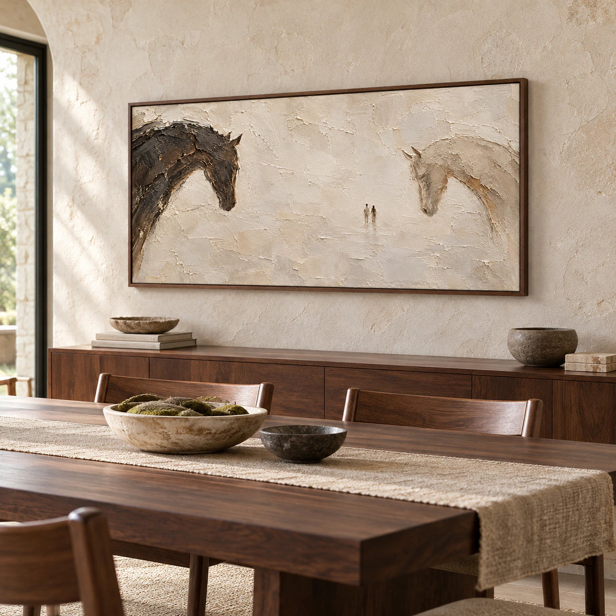 Wide horse painting on a light limestone wall above a long dark wood dining table with simple chairs, viewed from a slightly elevated right angle.