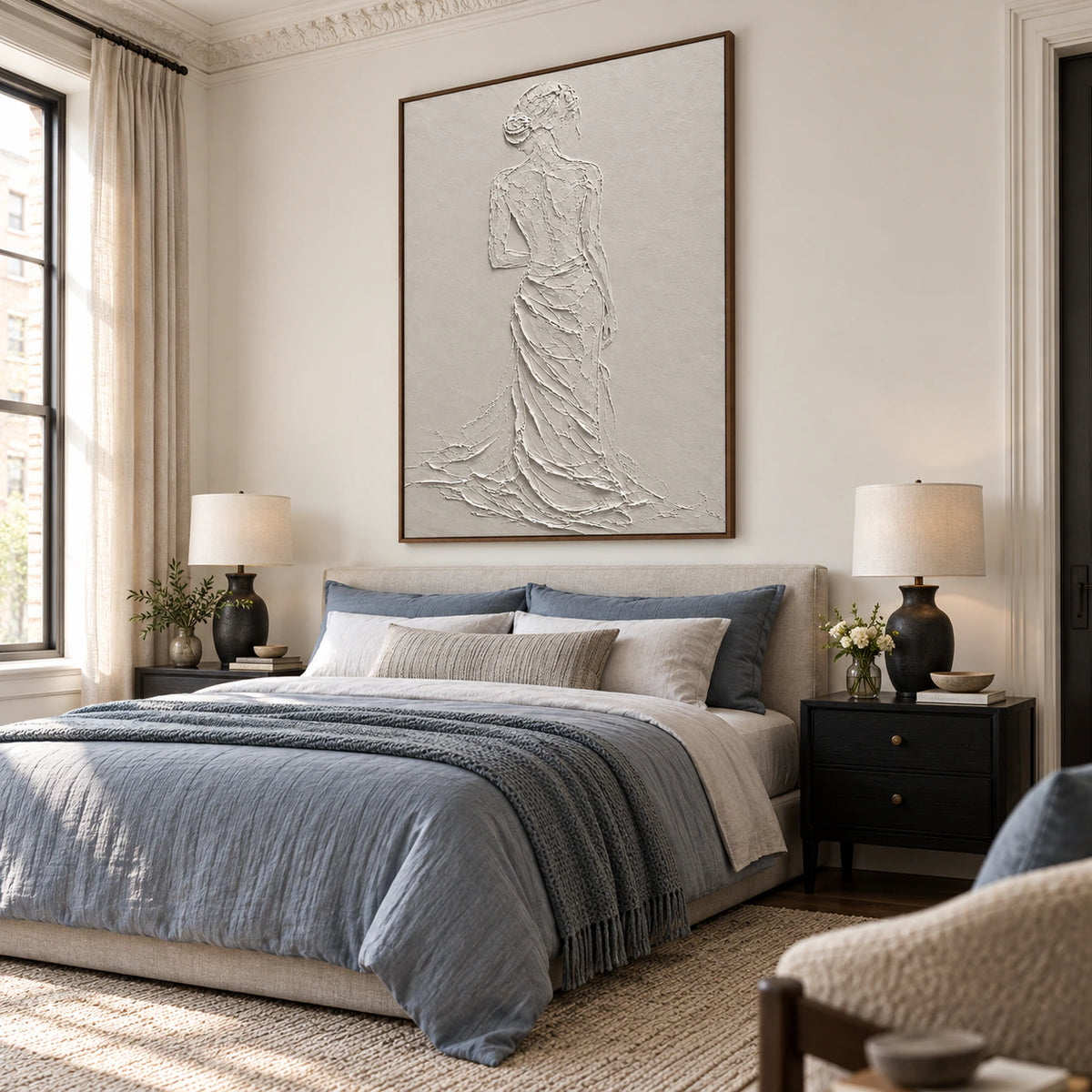 Textured ivory figure wall art as the focal point of a quiet, sunlit bedroom.