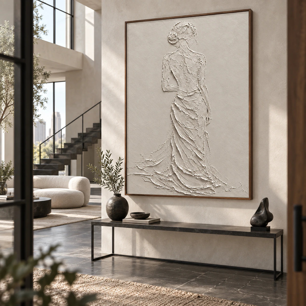 Gallery-scale ivory textured figure artwork in a bright, spacious foyer.