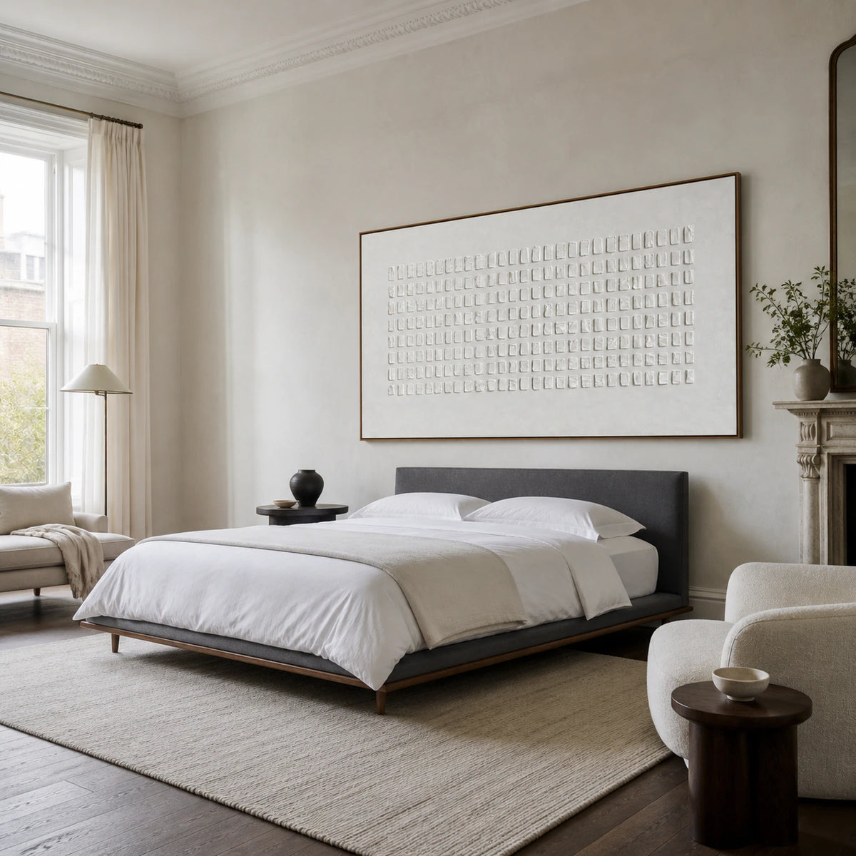 Quiet bedroom with the white geometric relief artwork above a low upholstered bed.