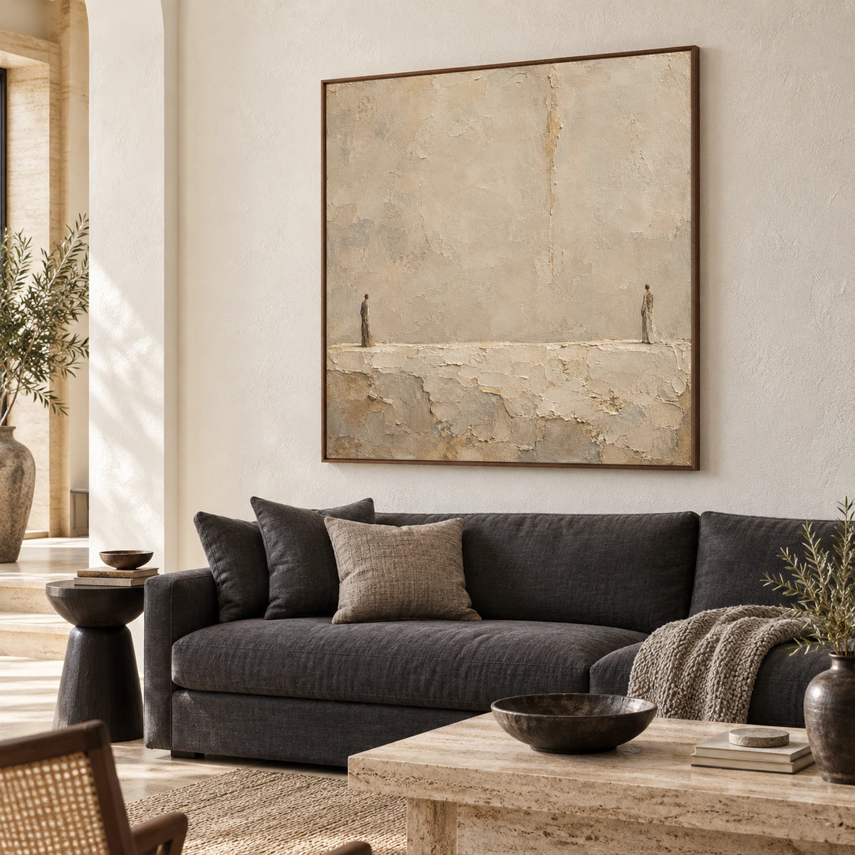 Square textured figure painting above a low neutral sofa in a bright living room.