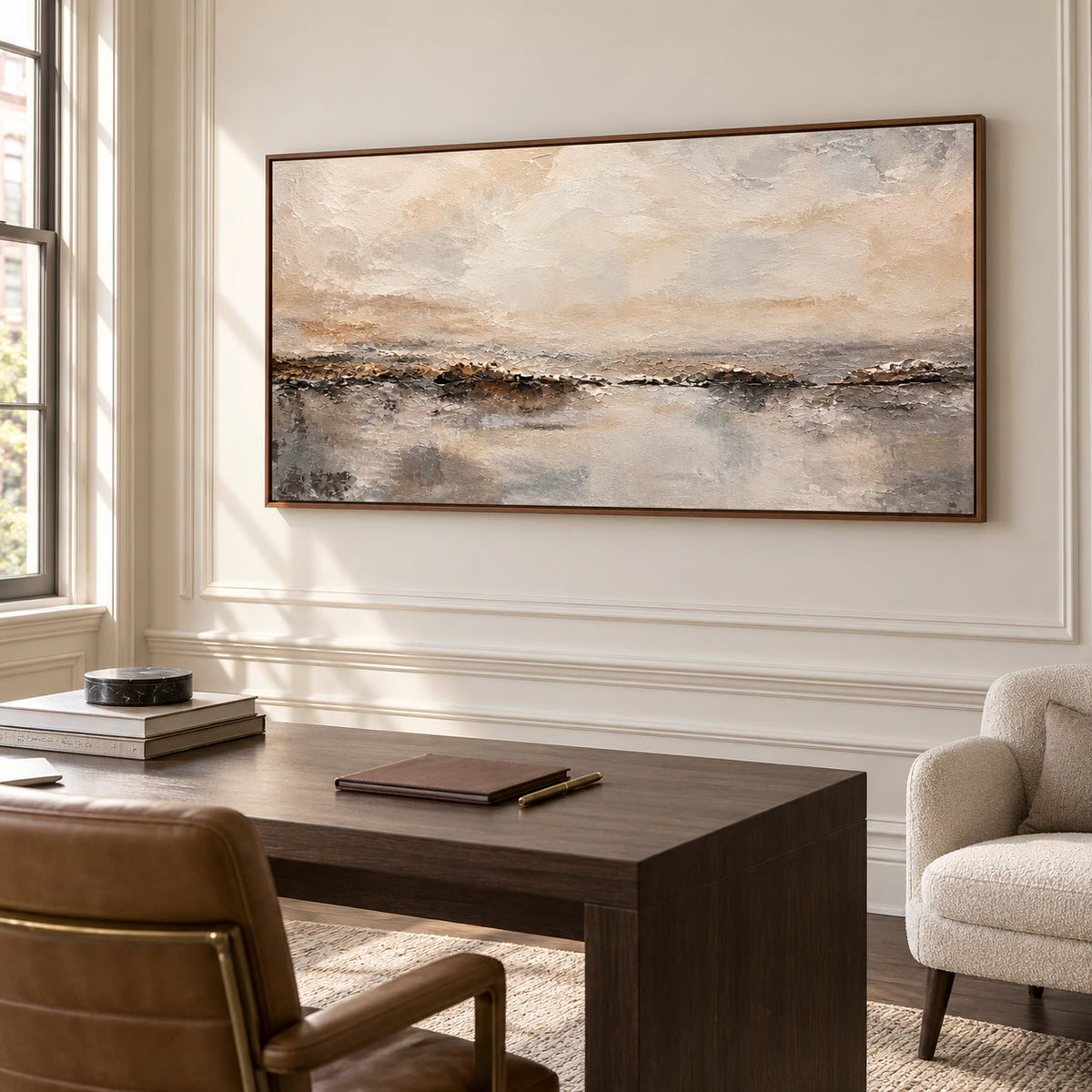 Large abstract horizon painting on a bright home office wall beside a simple desk and reading chair.