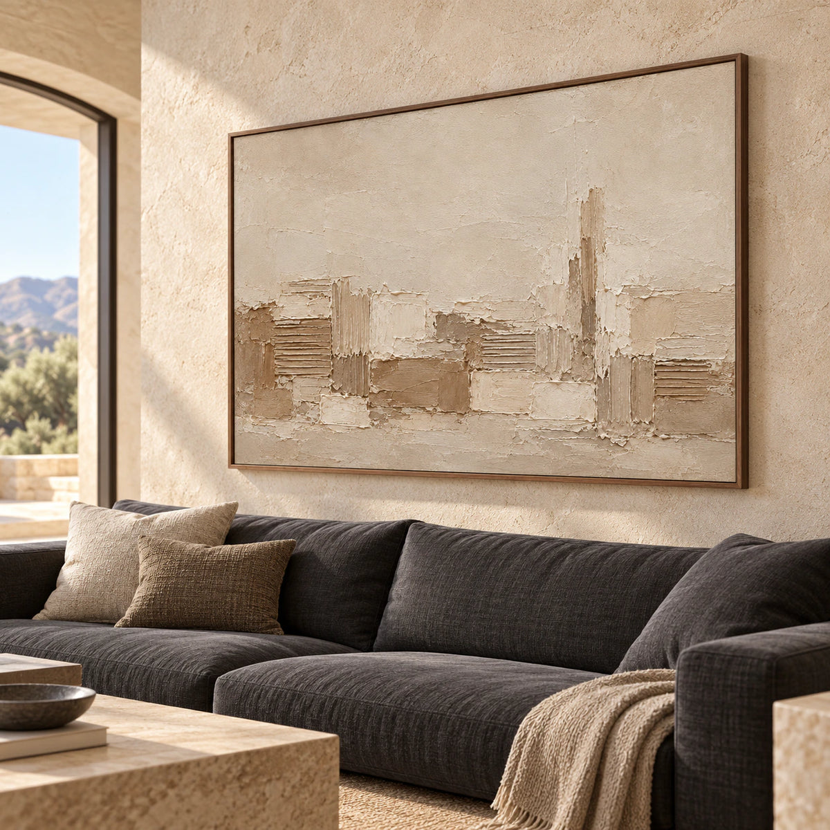 Large Raked Passage artwork anchors a bright living room above a charcoal sofa, viewed from the left at seated height.