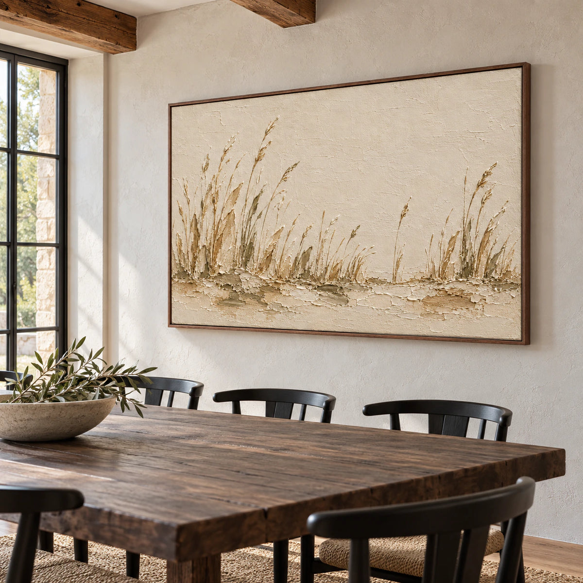 Right-oblique view of the reed landscape on a cool pale stone wall above a long dark wood dining table with simple black chairs.