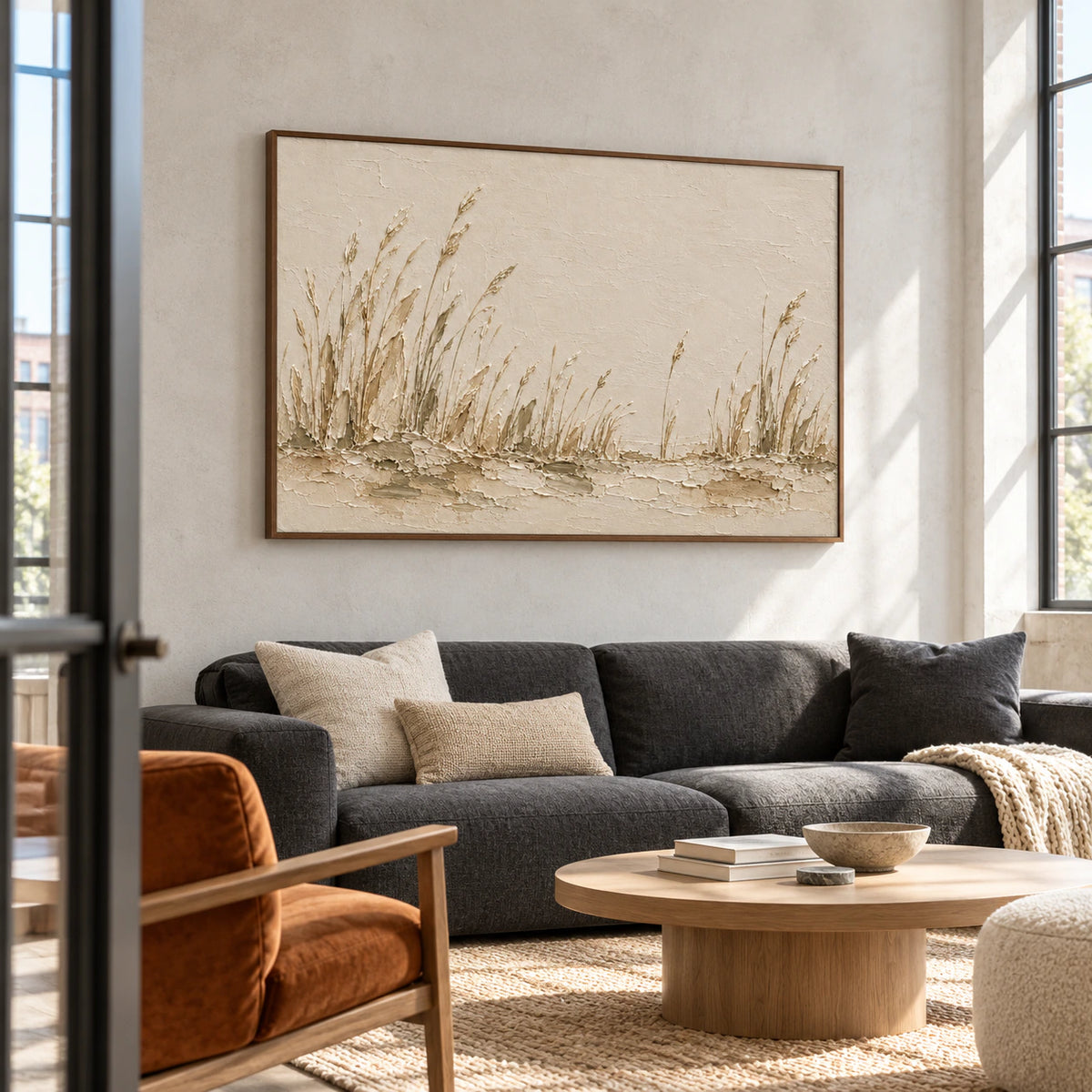 Eye-level left-oblique view of the reed landscape above charcoal seating in a spacious hospitality loft with concrete walls and tall industrial windows.