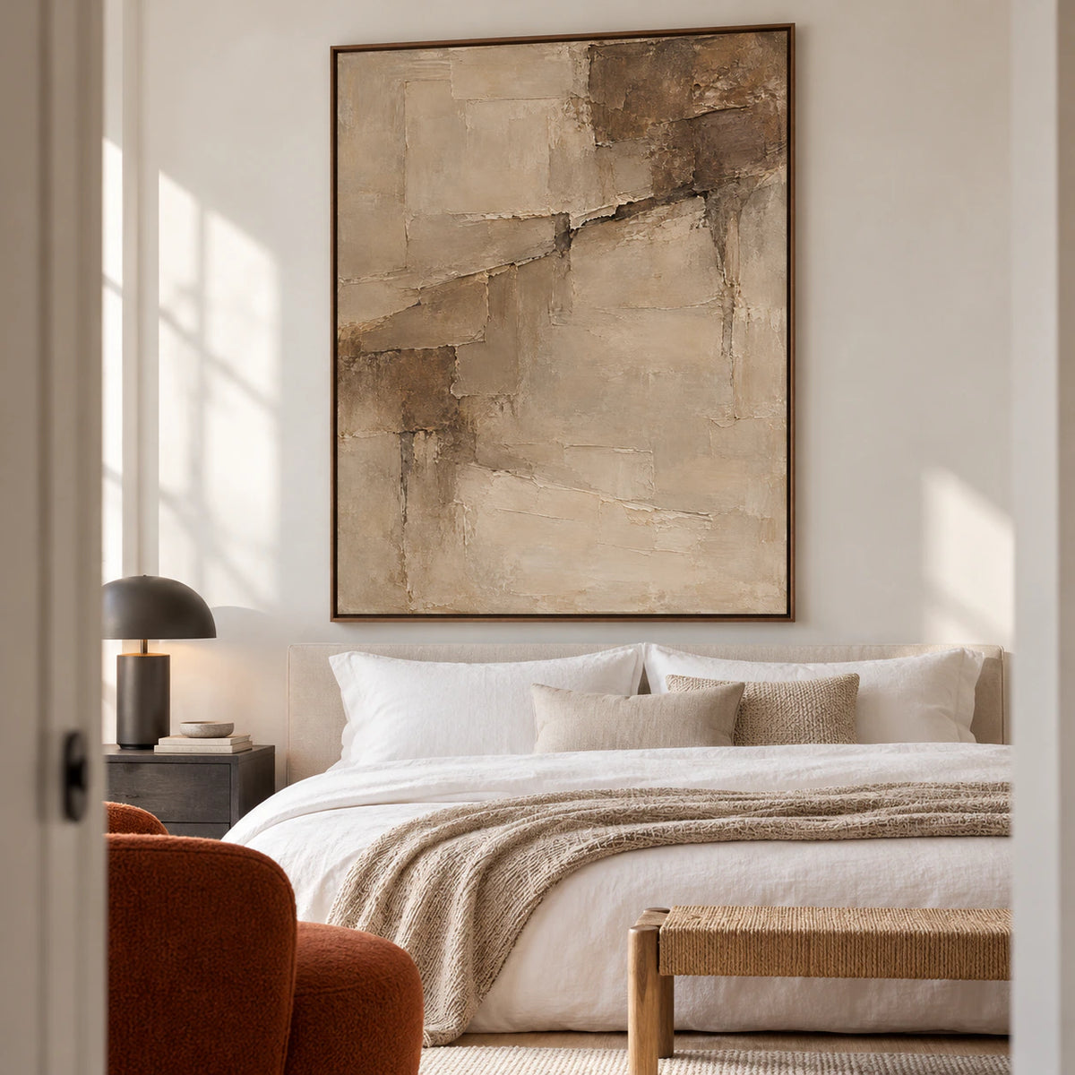 Riven-Parchment artwork above a simple bed in a quiet bedroom with soft white linen and open daylight.