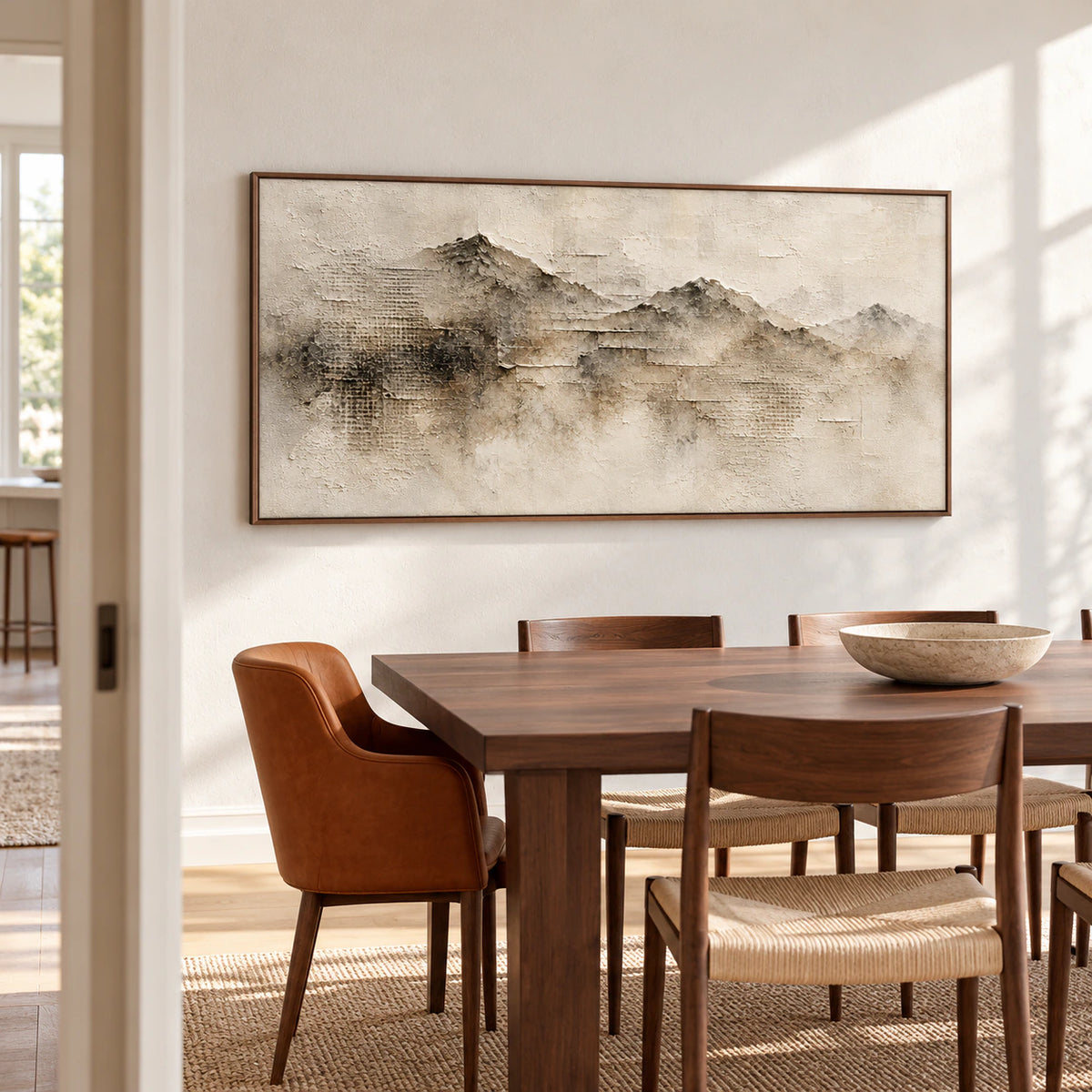 Panoramic ridgeline painting on a pale textured dining room wall, viewed from the left beside a dark walnut table and slim chairs in daylight from high windows.