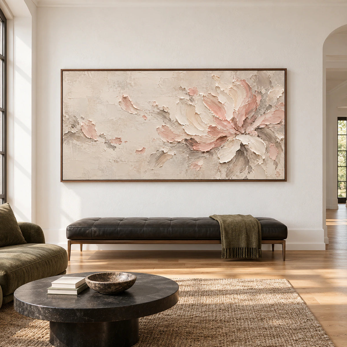 Large horizontal ivory and blush floral abstract above a low bench in a bright, spacious interior, viewed straight on.