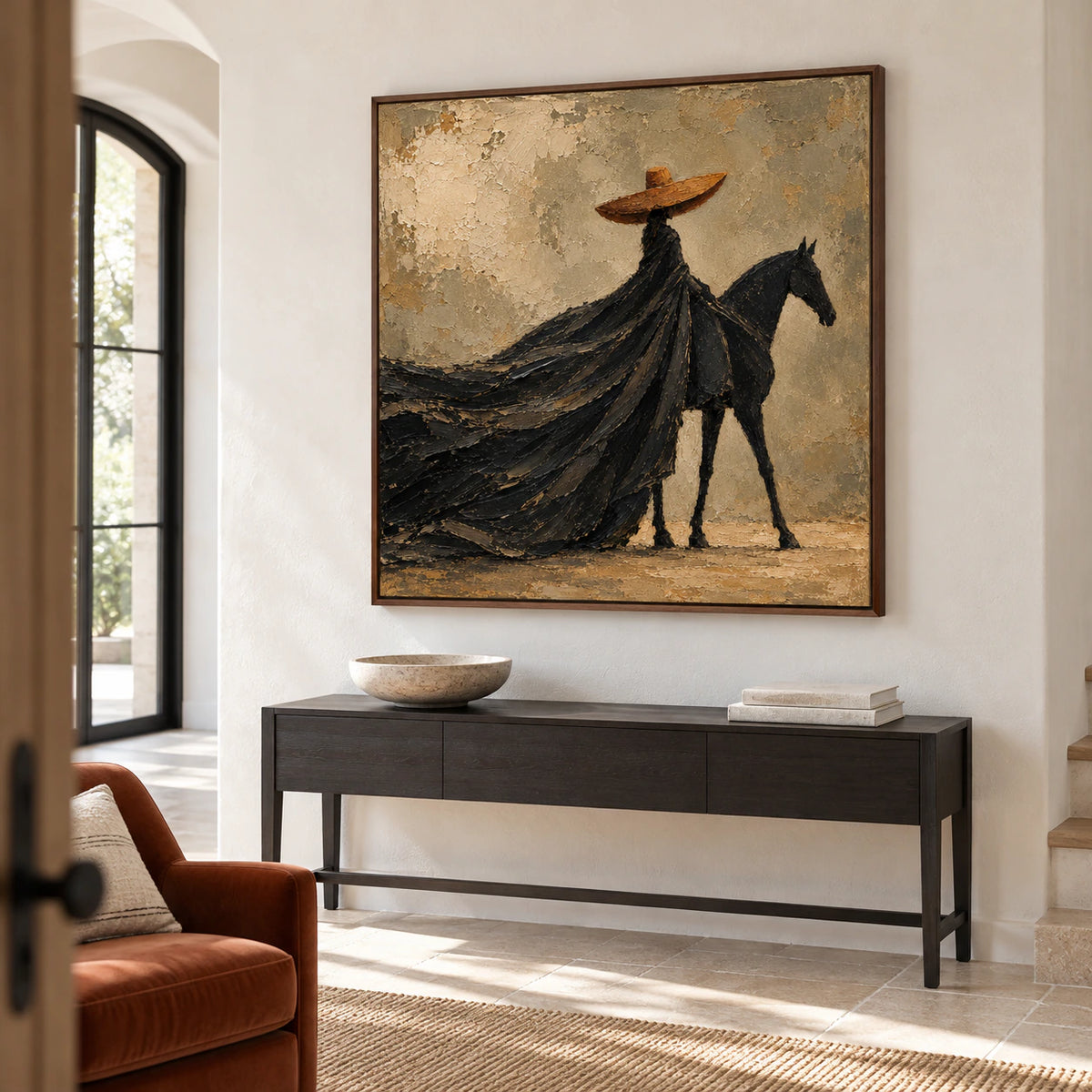 Large square rider-and-horse painting in a tall, bright foyer with pale stone architecture and a narrow dark console, viewed obliquely from the left.