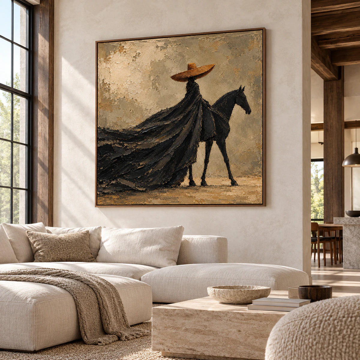 Large square rider-and-horse painting on a pale concrete wall in a sunlit loft with visible timber structure and pale furniture, viewed from a distant right-oblique angle.