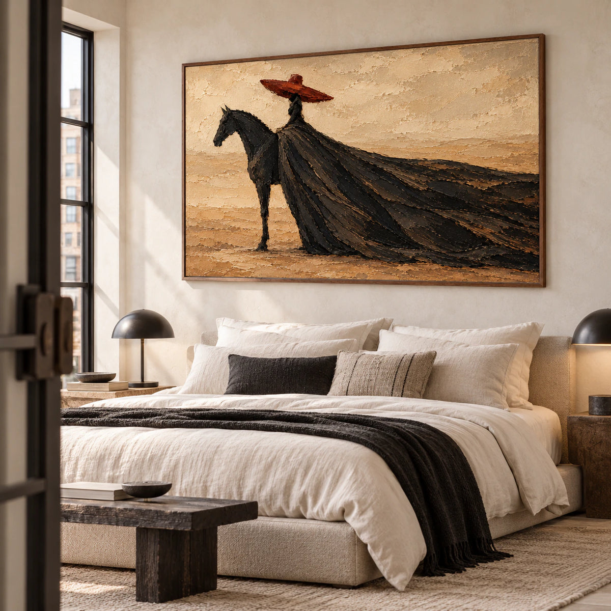 Large horizontal rider painting above a simple upholstered bed in a quiet, bright bedroom with restrained neutral furnishings.