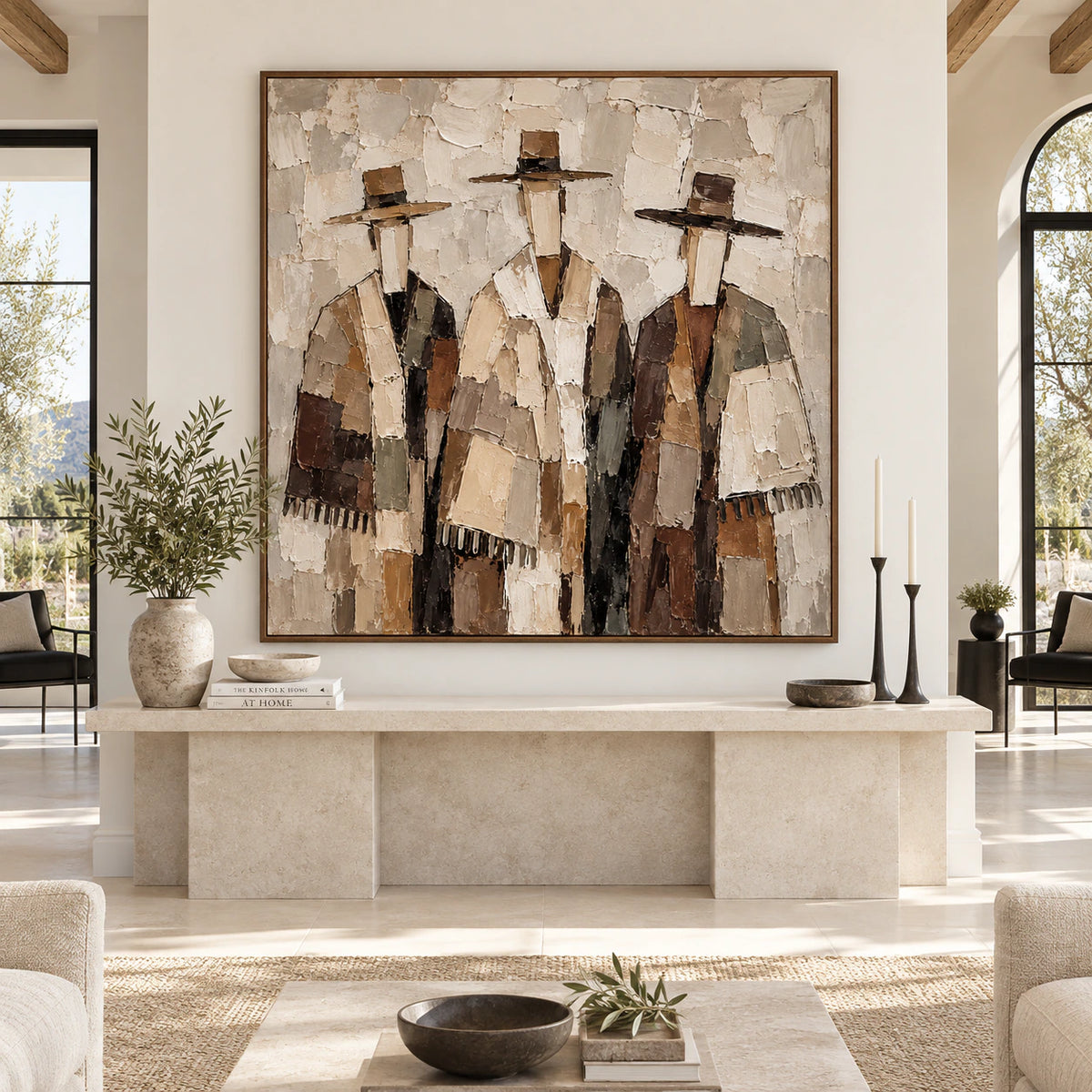 Large square figure artwork above a low stone console in a sunlit architectural living space.