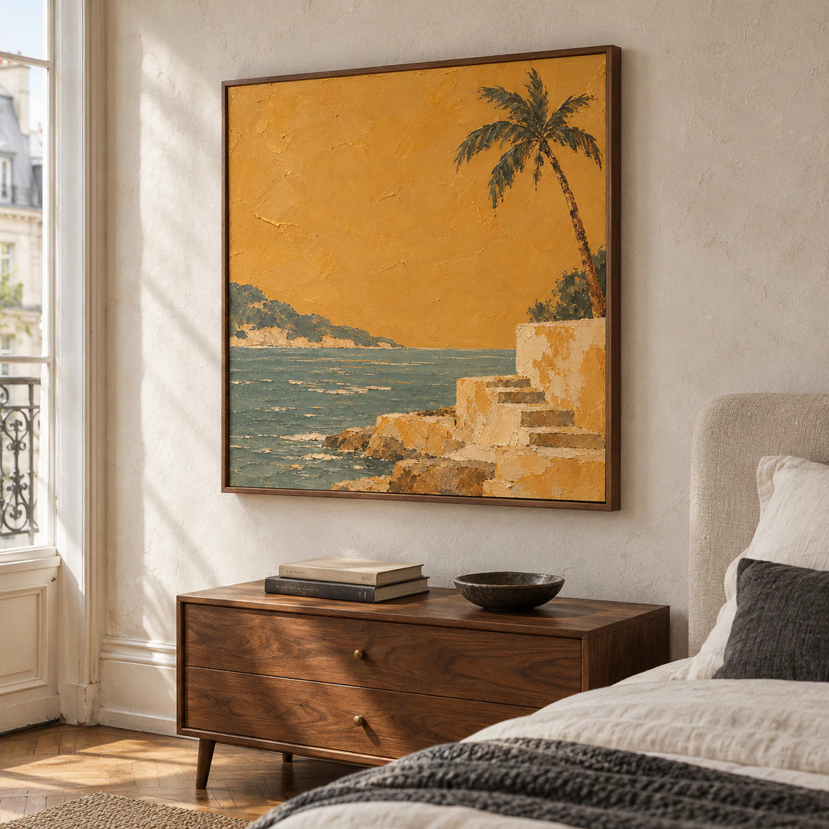 Square coastal painting above a walnut bedside console in a quiet, sunlit bedroom with ivory linens and muted charcoal accents.