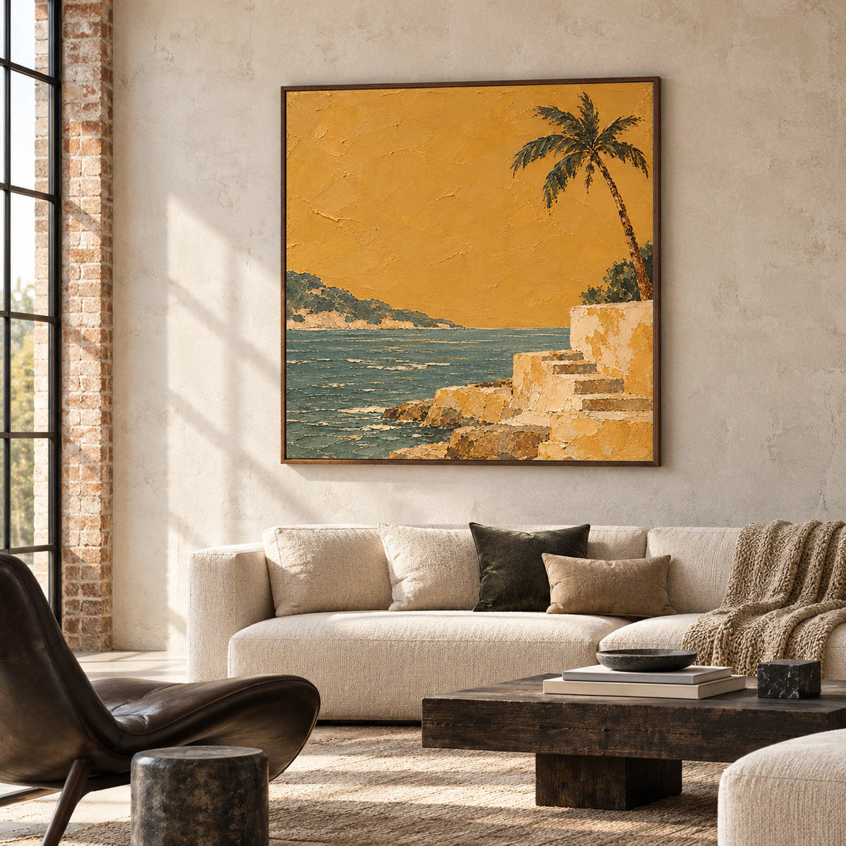 Large square coastal painting in an expansive loft lounge, set against a pale concrete wall with dark sculptural seating and broad daylight.