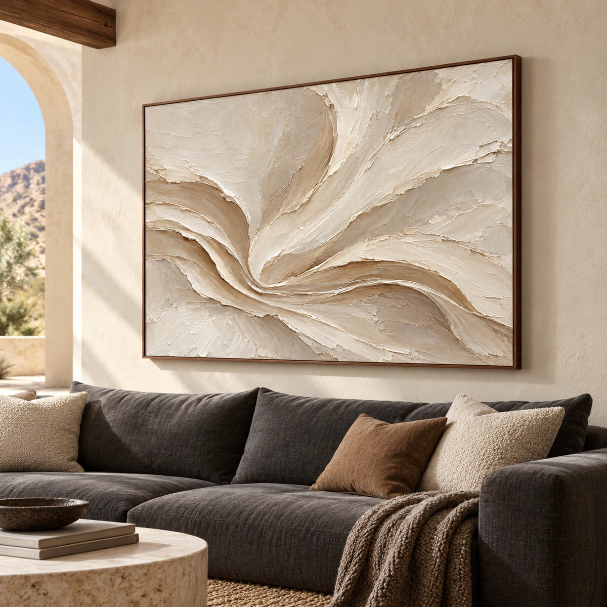 Satin-Whorl hangs above a low charcoal sofa in a bright living room with pale walls and natural daylight.