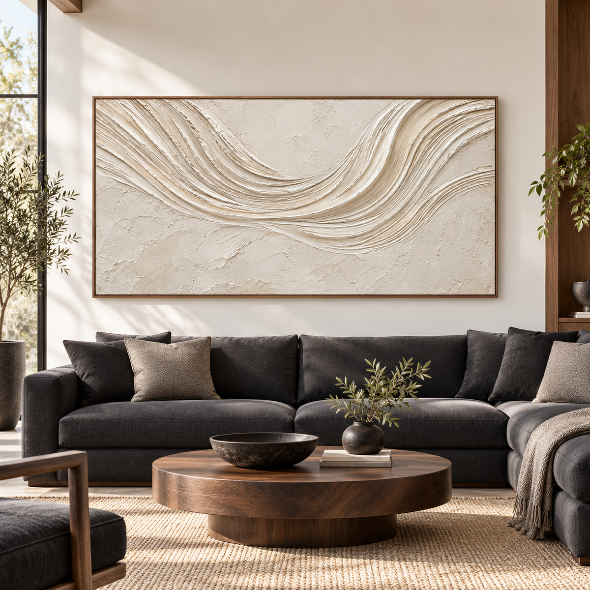 Straight-on view of a large horizontal ivory and sand-toned abstract painting in a bright, spacious room with dark wood and charcoal furnishings.