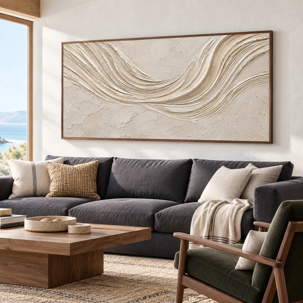 Left oblique view of the horizontal ivory abstract painting above a charcoal sofa, with walnut accents and a muted rug in a bright living room.