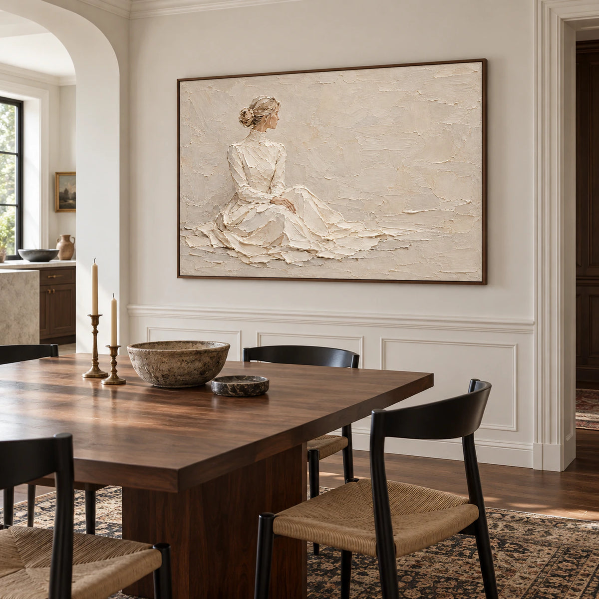 Horizontal ivory and sand figure artwork anchoring a refined dining room with a dark walnut table, sculptural chairs, and soft daylight.