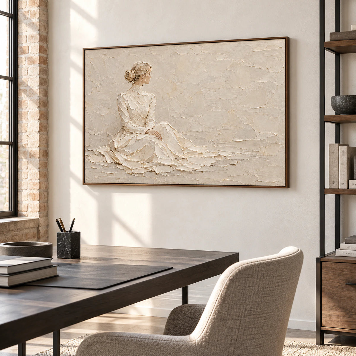 Large horizontal artwork in an airy home office with a simple black desk, pale walls, open shelving, and bright window light.